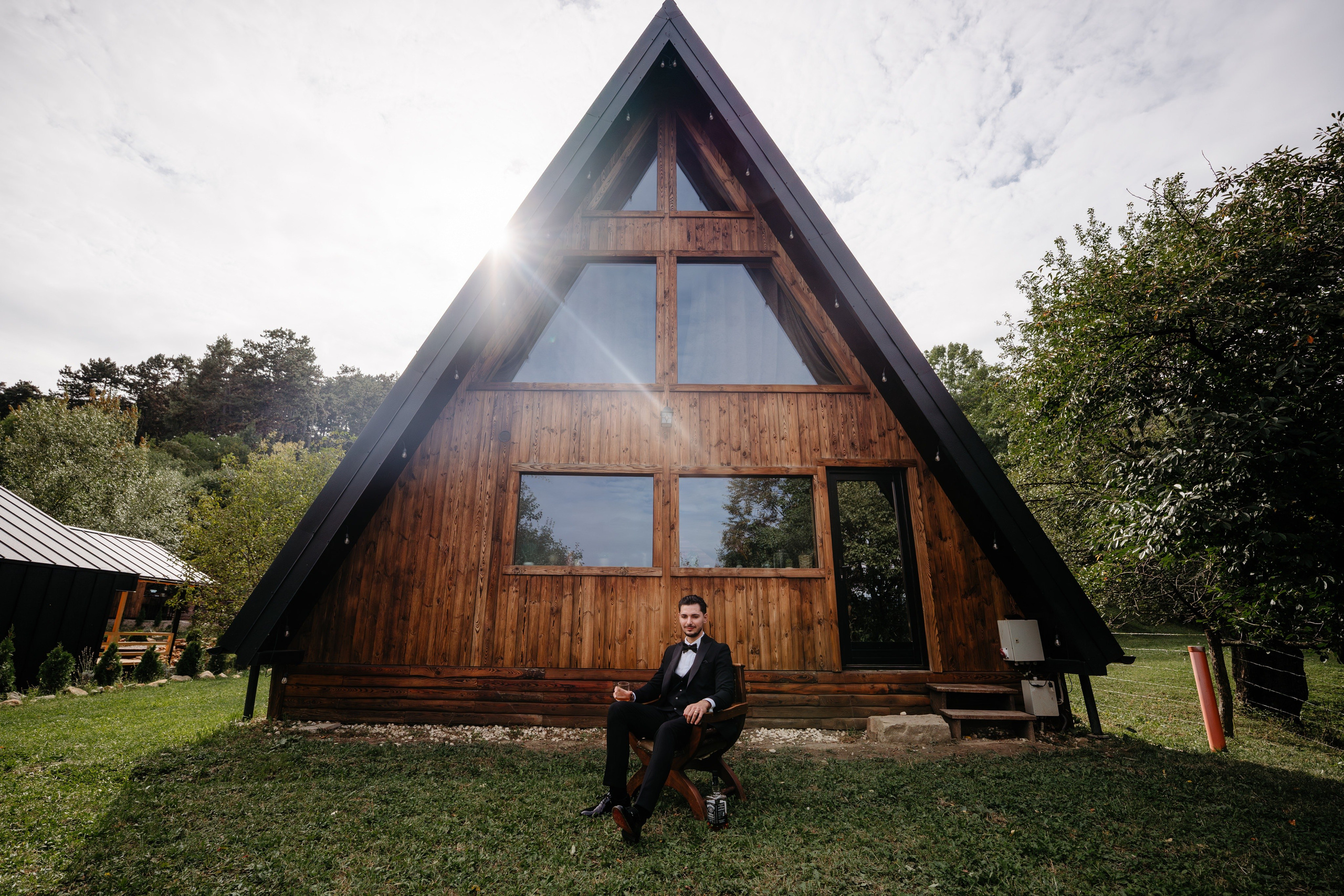 Mirii în fața cabanei tip A-frame din Comănești, locație nuntă în natură.