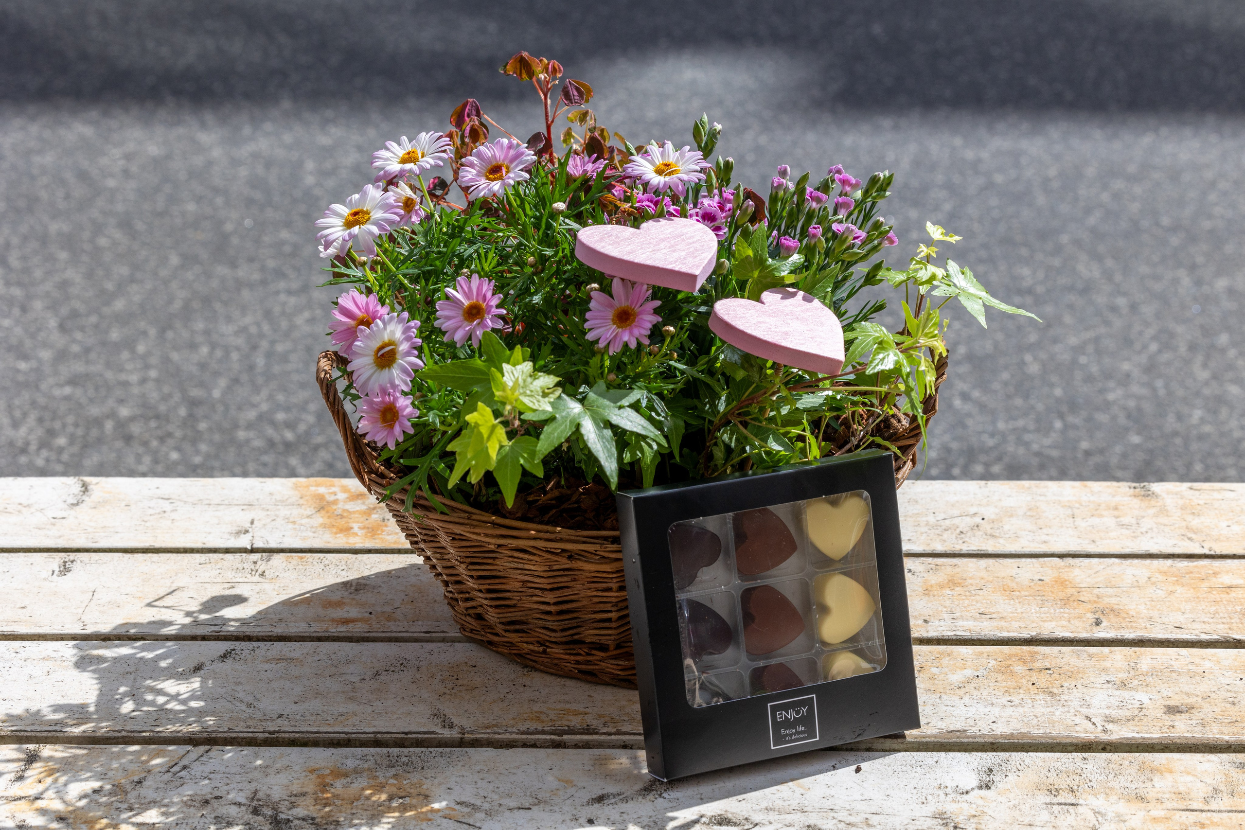 Send en smuk lyserød hilsen sammen med de skønne hjerte chokolade . Planterne i sammenplantningen kan variere alt efter sortimentet.