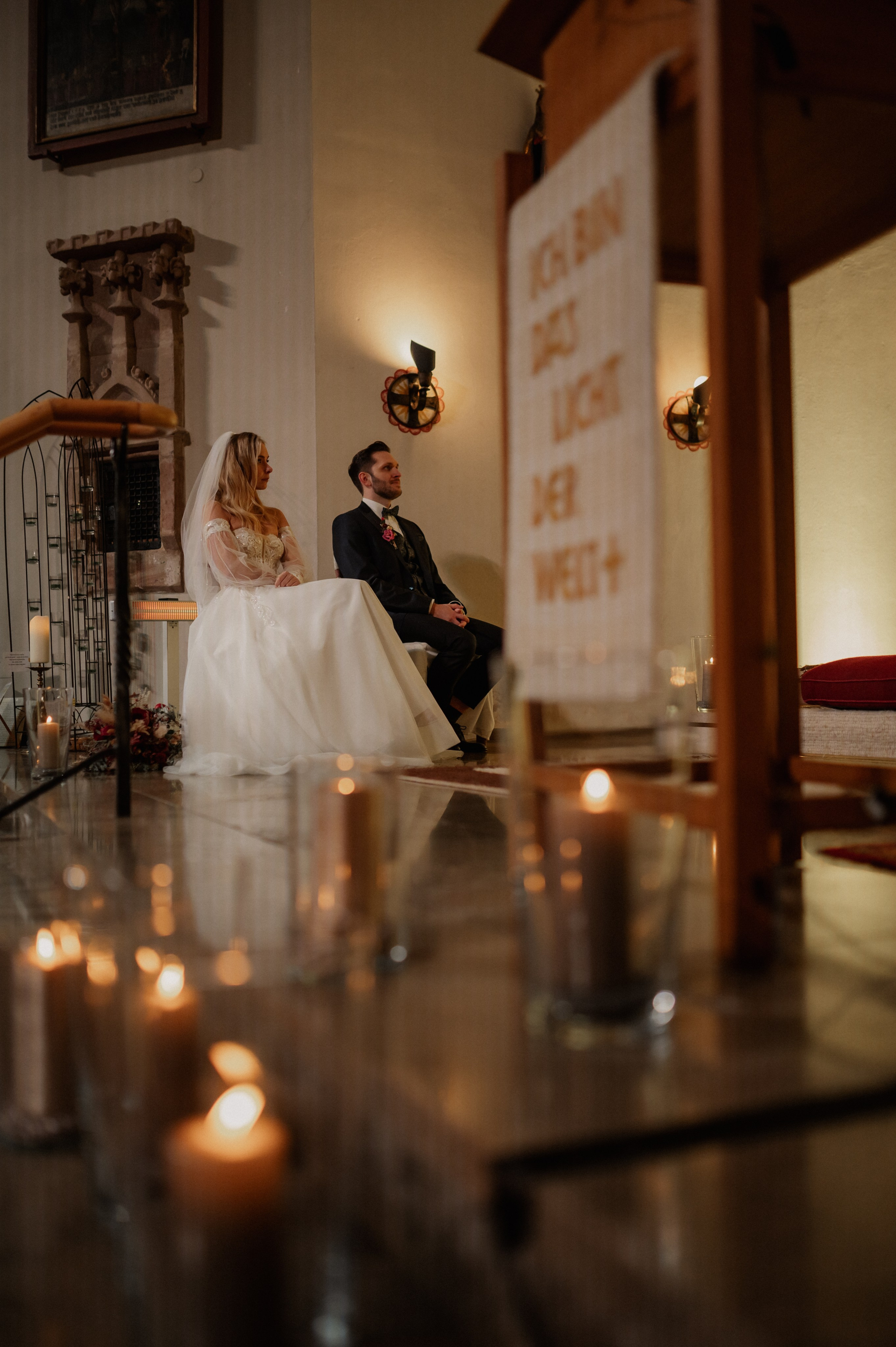 Kerzen scheinen im Vordergrund bei der Hochzeit in Neuendettelsau