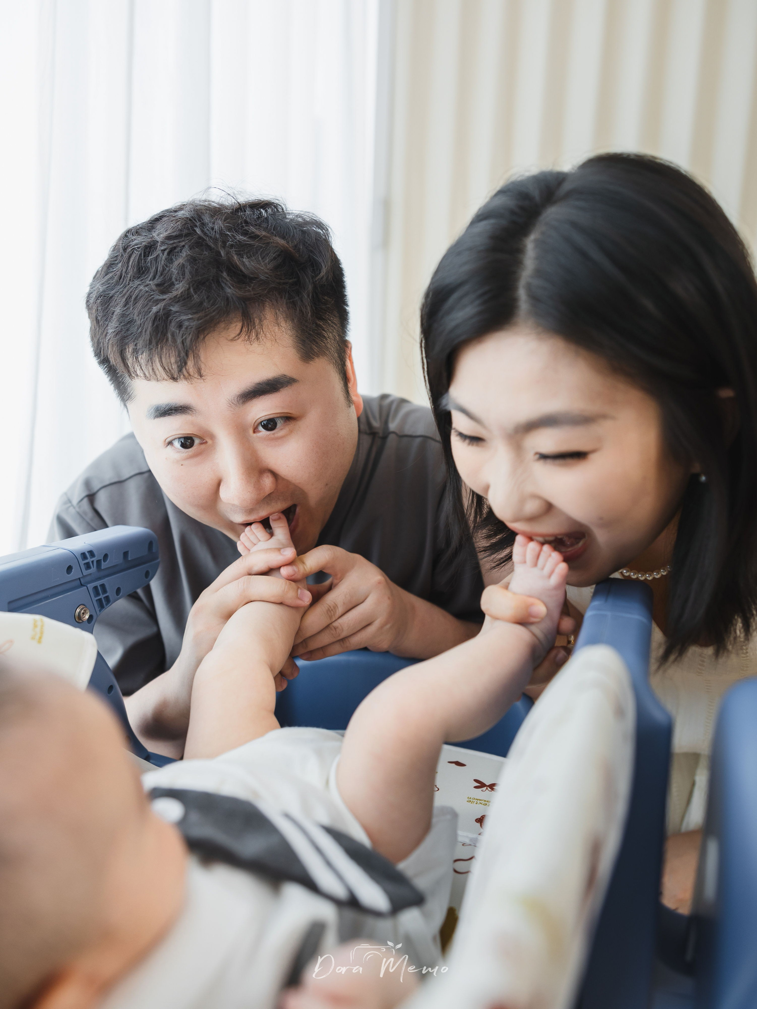 Expressive parents laughing and playing with their baby during a lifestyle family photography session.