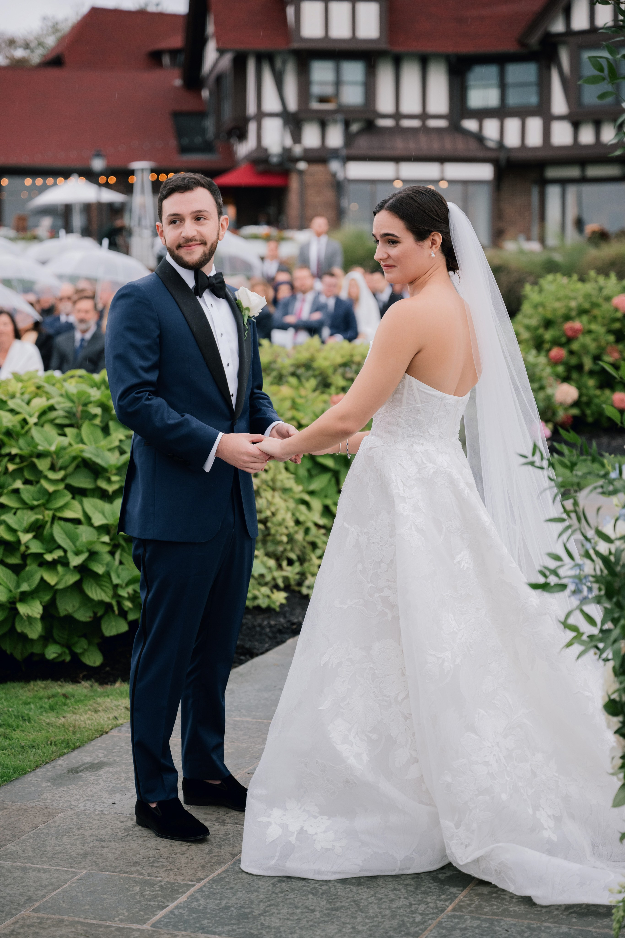 a bride and groom are standing in front of a large building