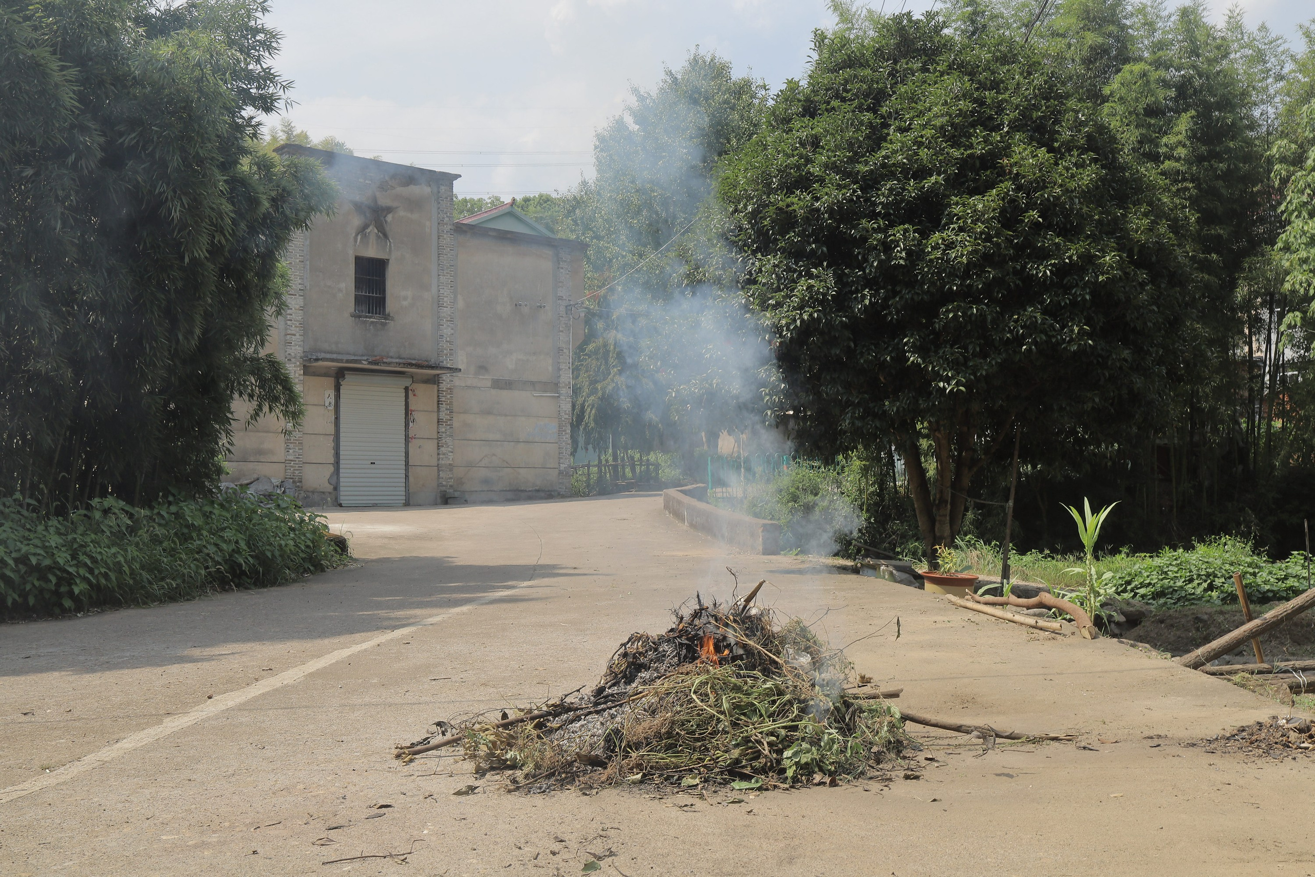 Villagers burn hay on the roadside in Gao Ban Ling Jiao. Ashes can be used as soil fertilizer for farming. The hay is usually corn stalks. The house behine is the village community center, where weddings, funerals, and festivals were once held. It’s rarely used nowadays.