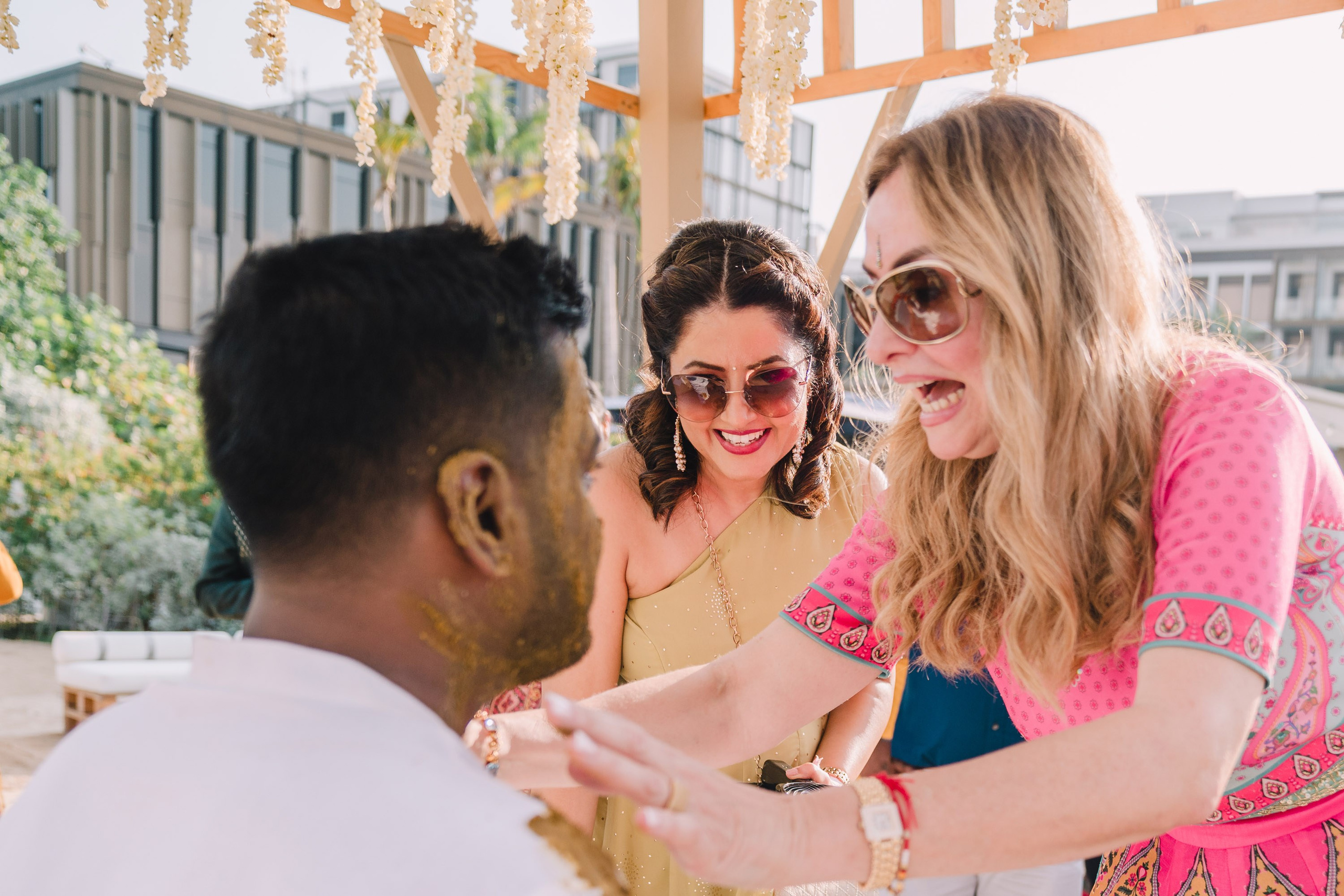lady in a pink dress is touching the groom on a ceremony