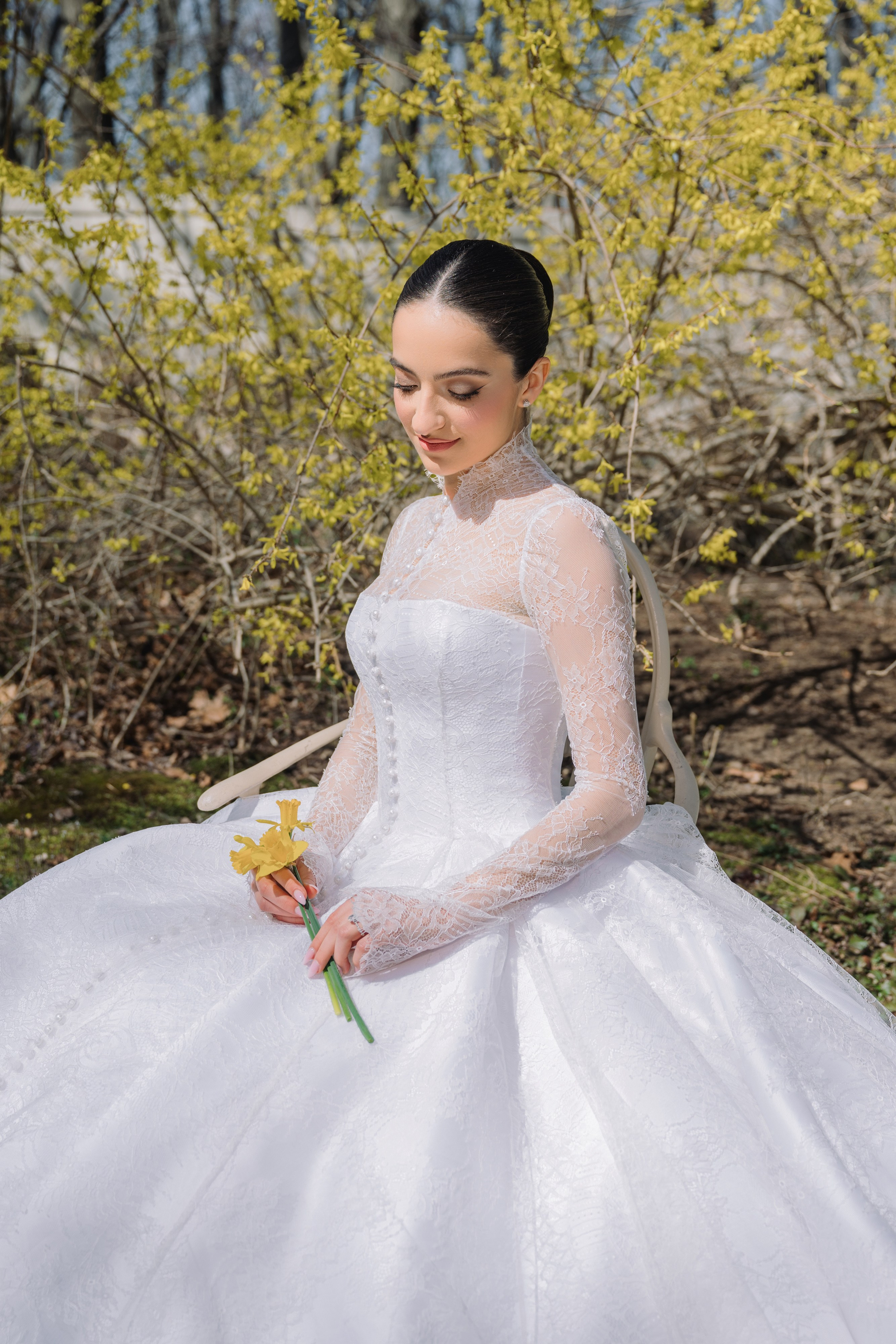a woman in a white wedding dress sitting on a rock