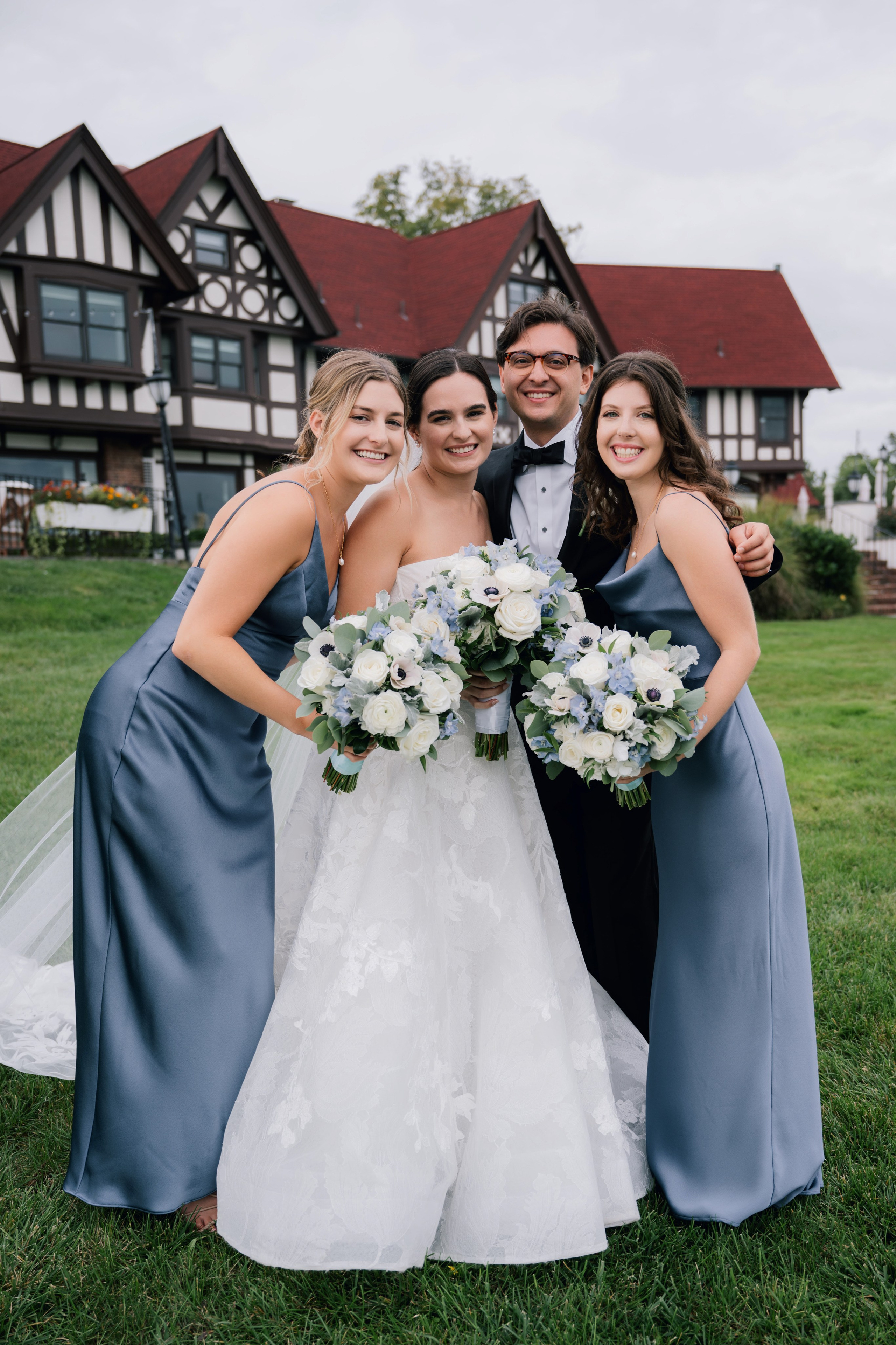a bride and her bridesmaids pose for a photo in front of the lodge at the grand