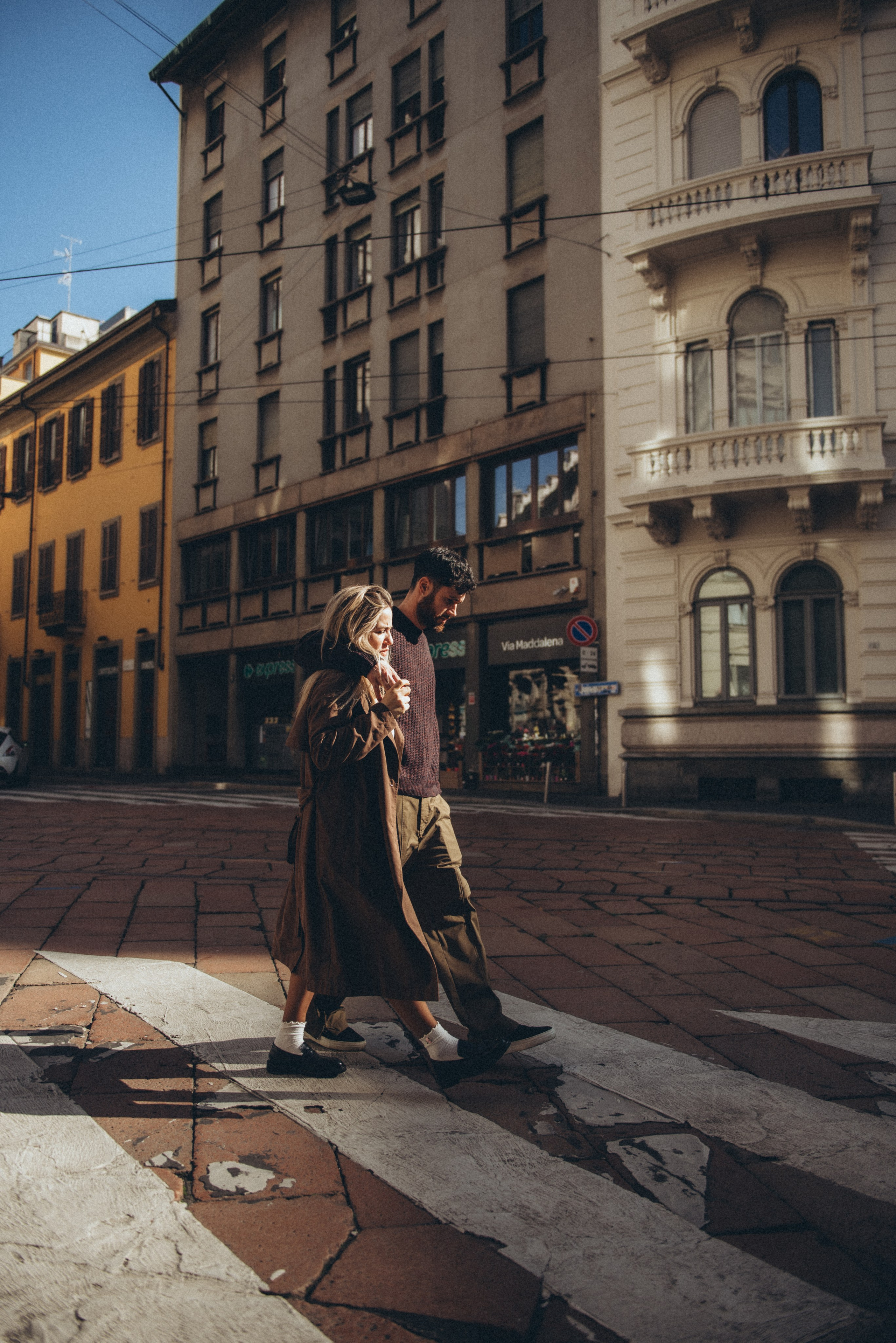 Romantic scene of a couple sharing a quiet moment in a Milan square in the morning. Milan love story photographer. Romantic photo walk in Milan