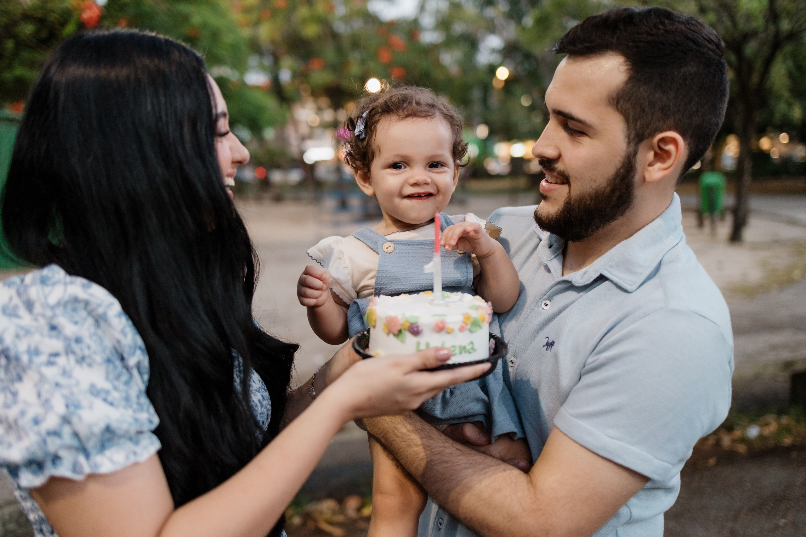 Família cantando parabéns de 1 ano em ensaio no parque