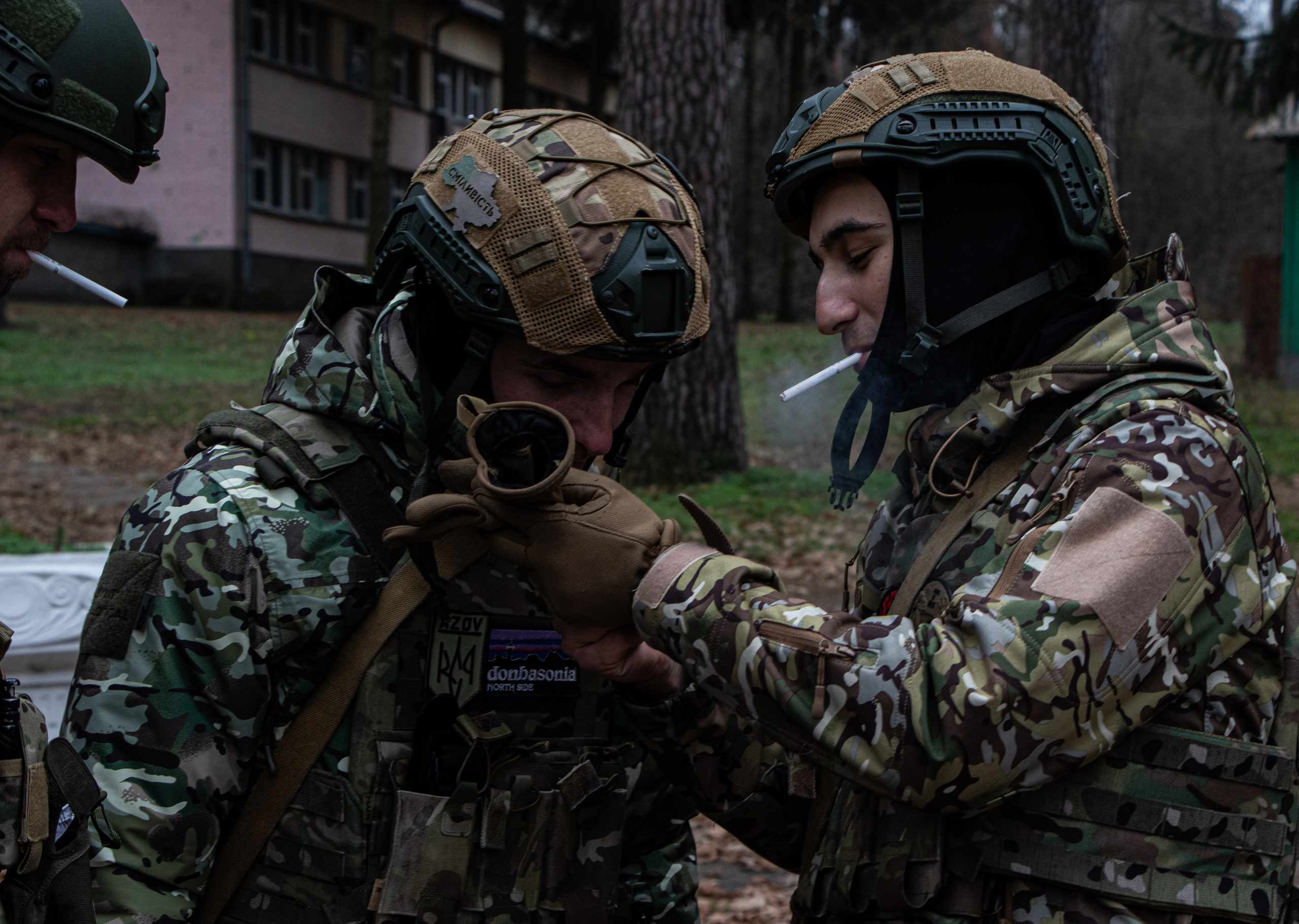 Des soldats ukrainiens fument une cigarette dans une base dans les environs de Kyiv.