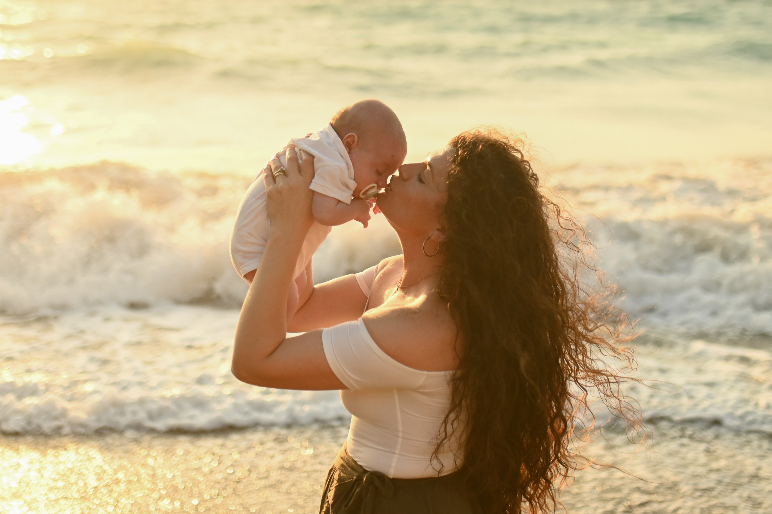 Happy family walking along a Rhodes beach at sunset. Photographer in Rhodes Island