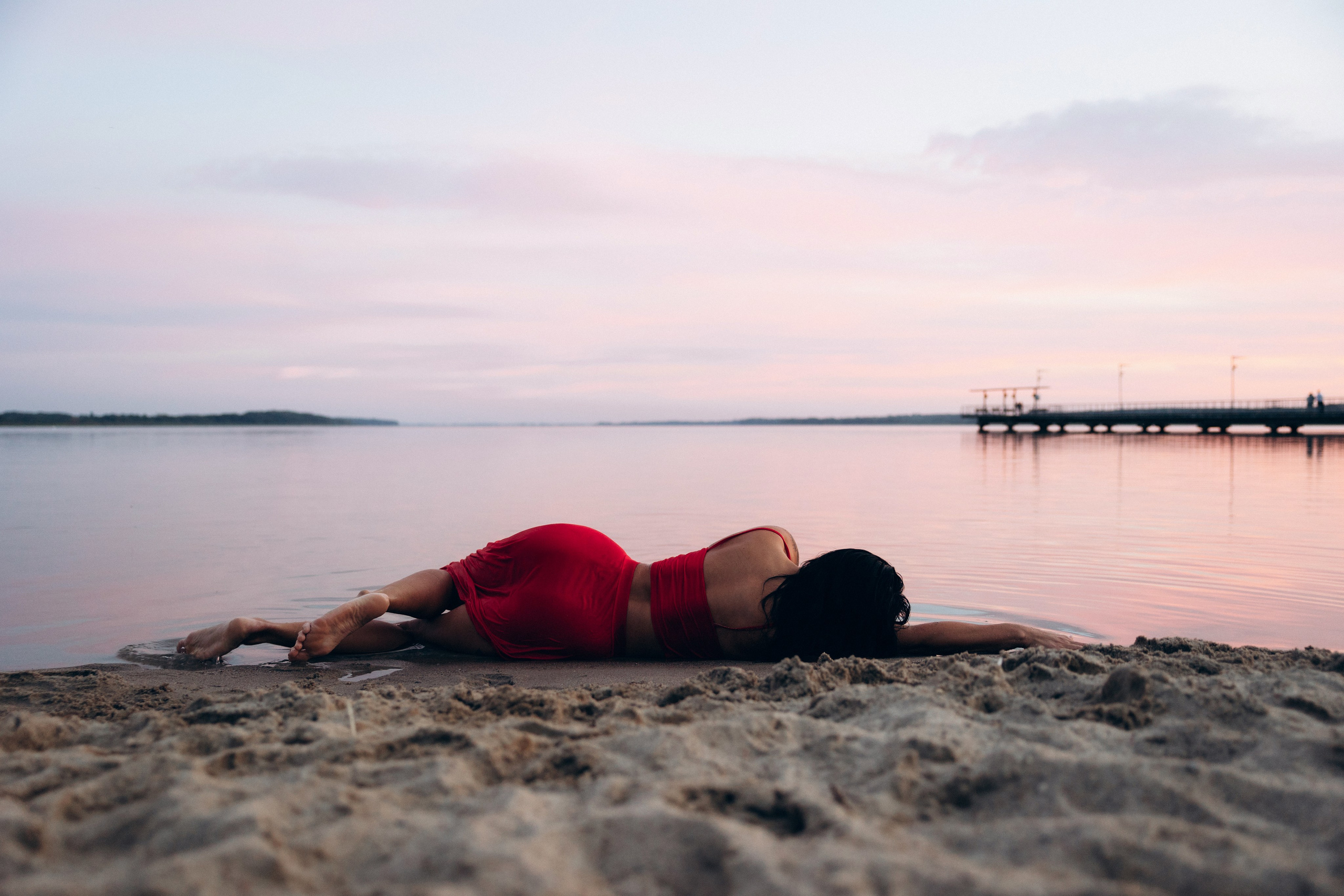 Kobieca sesja plenerowa nad wodą o zachodzie słońca