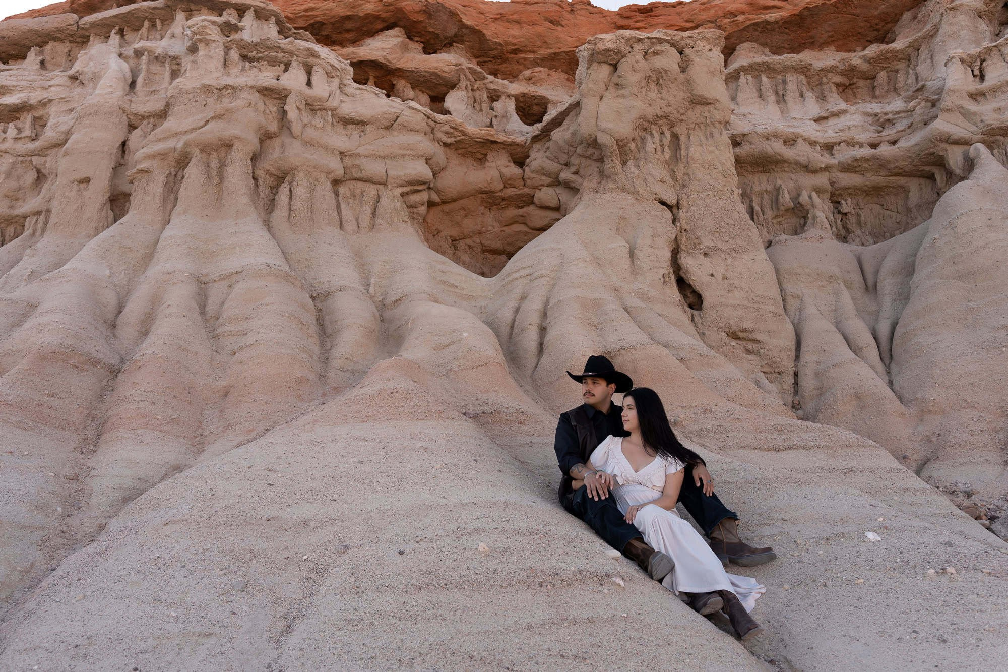 A couple posing at Red Rock Canyon State Park with the wind adding a dramatic effect