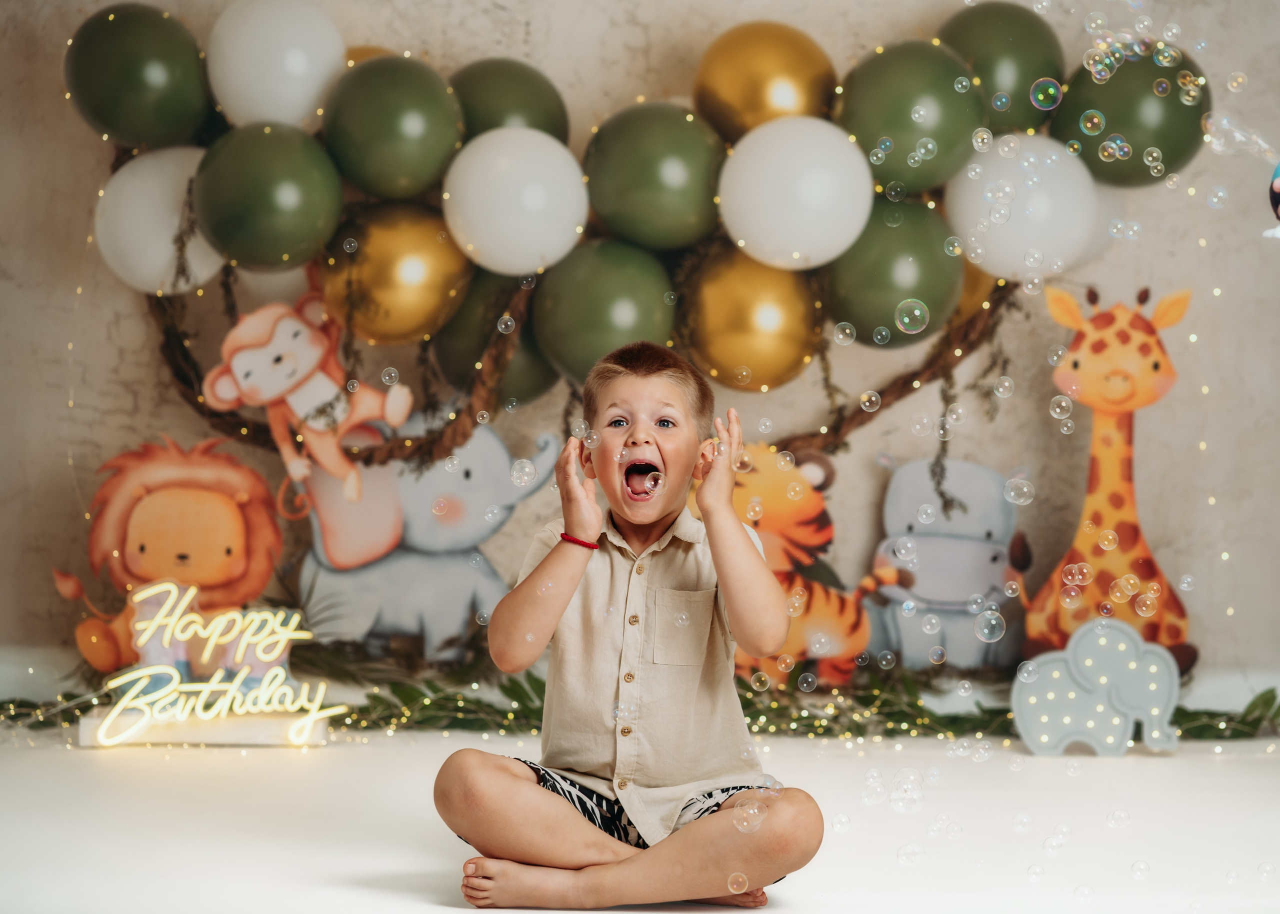 Fotografisanje drugog rođendana u džungla temi sa životinjama i lampicama