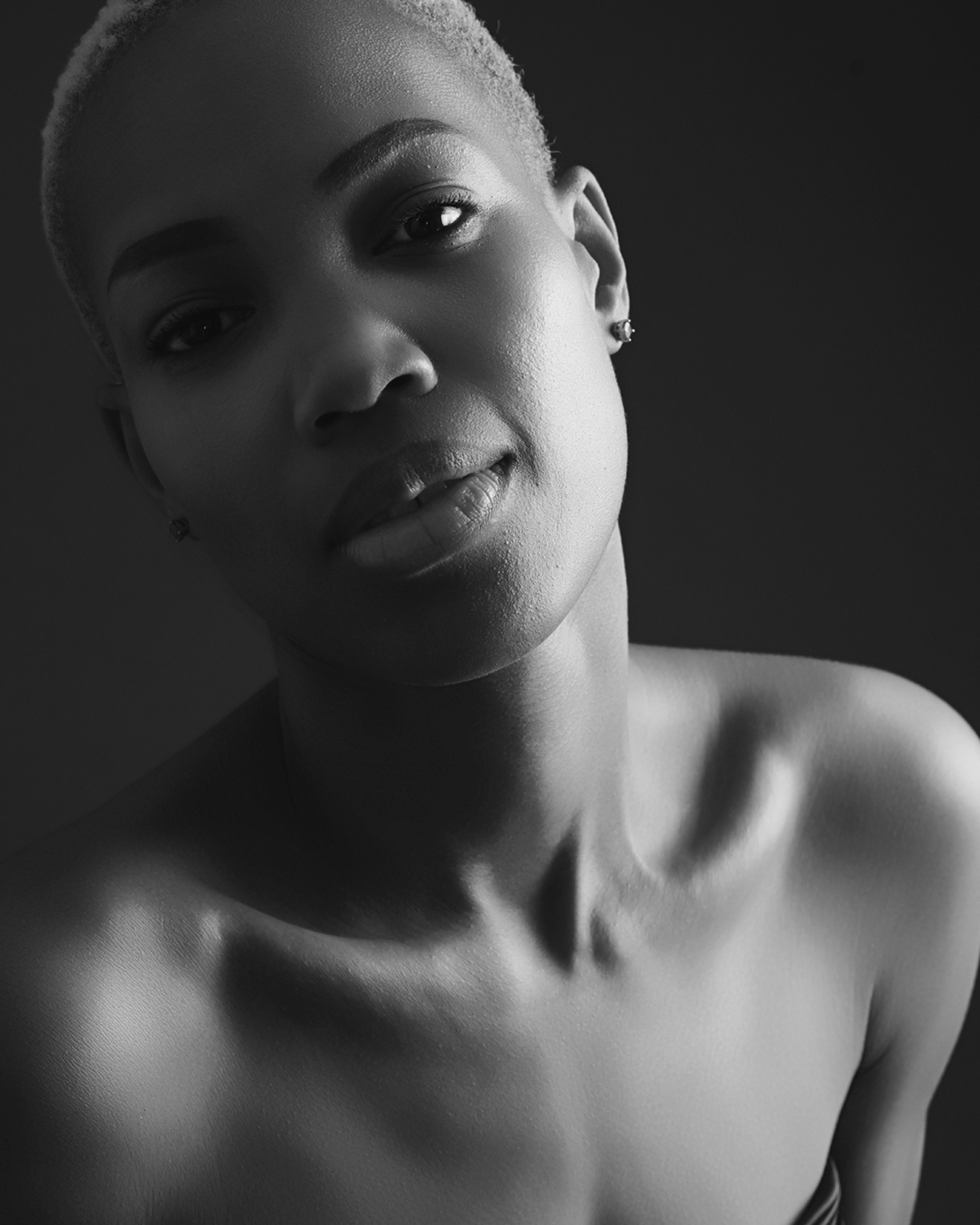 Künstlerisches Frauenportrait mit sanftem Licht und Schatten – zeitlose Eleganz und Ausdrucksstärke in einer minimalistischen Inszenierung.