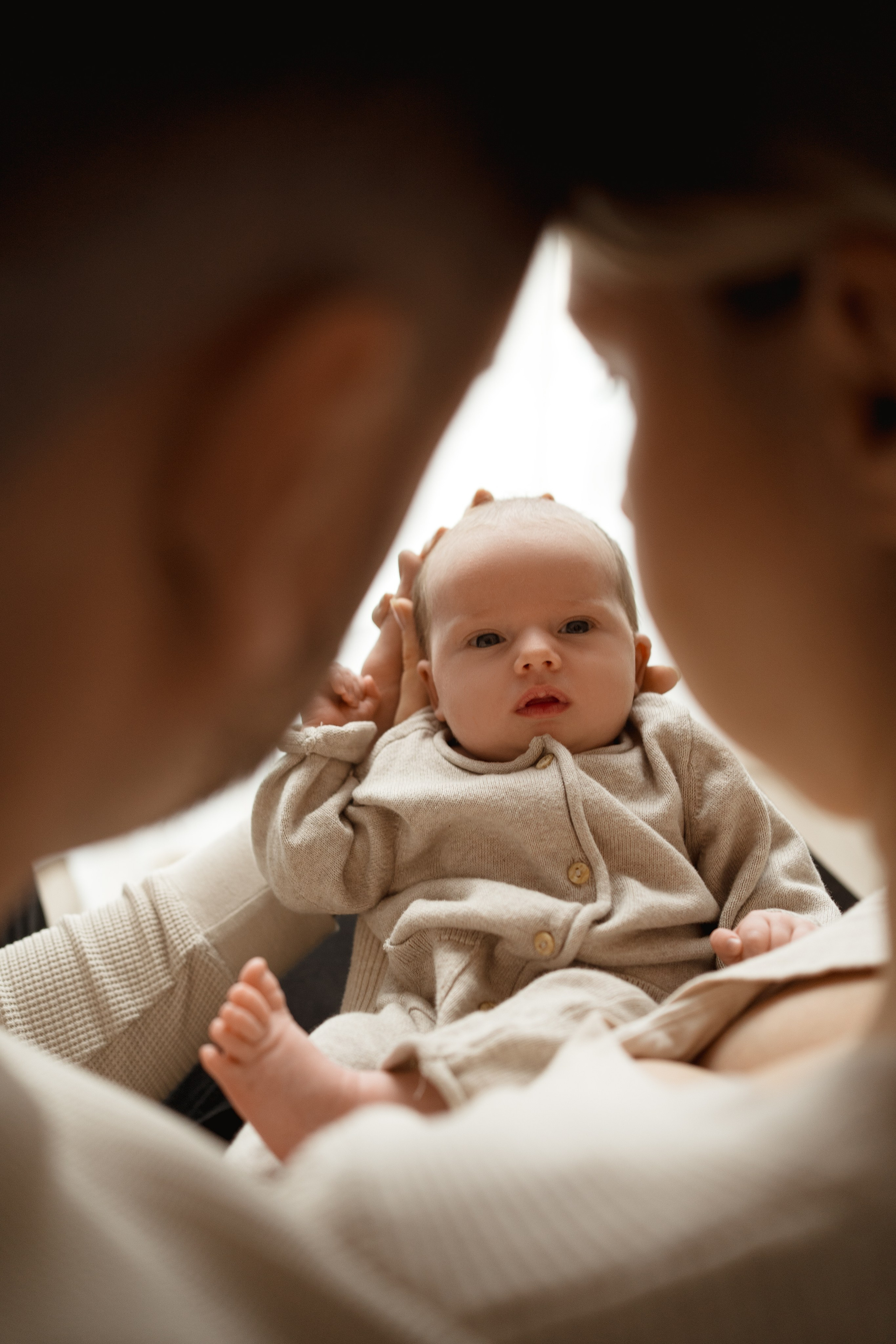 Mama obejmująca dziecko w łóżku – sesja noworodkowa w Łodzi