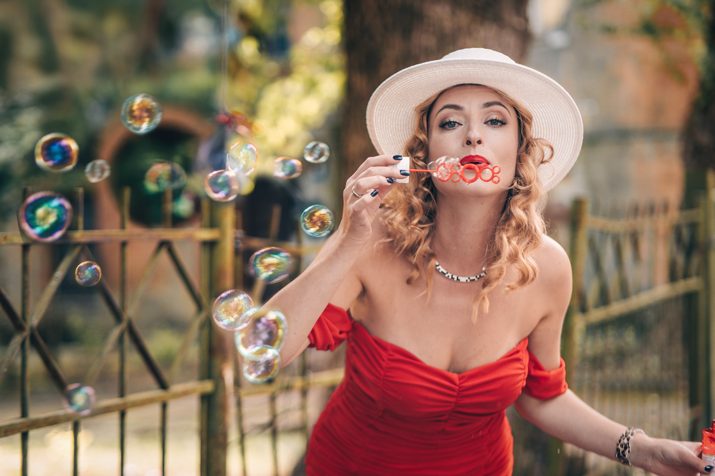 A woman in a red dress is blowing bubbles, Riga photographer