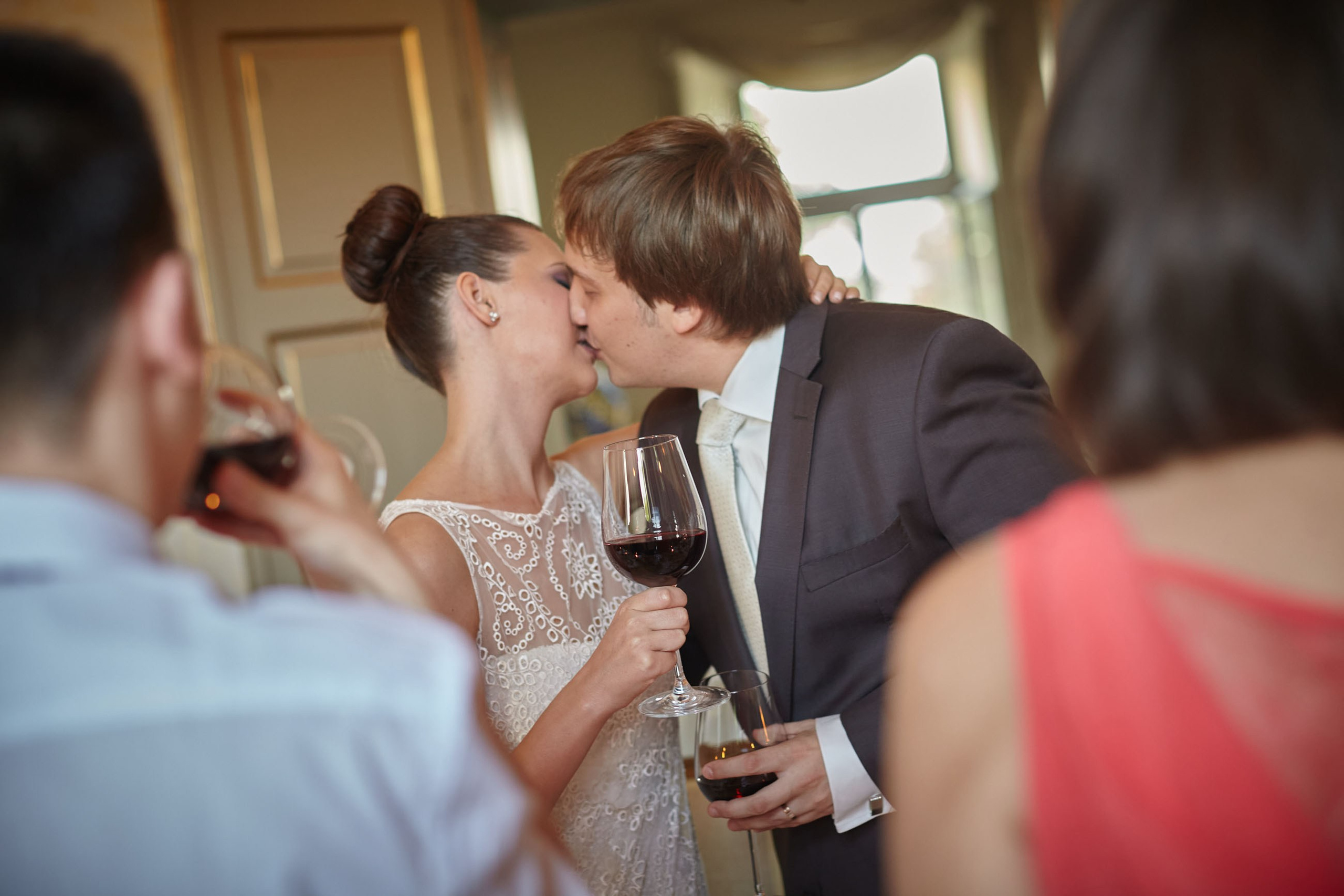 Family and friends encourage the newlyweds to kiss with the phrase 'Gorko' as they hold aloft their red wine glasses in celebration.