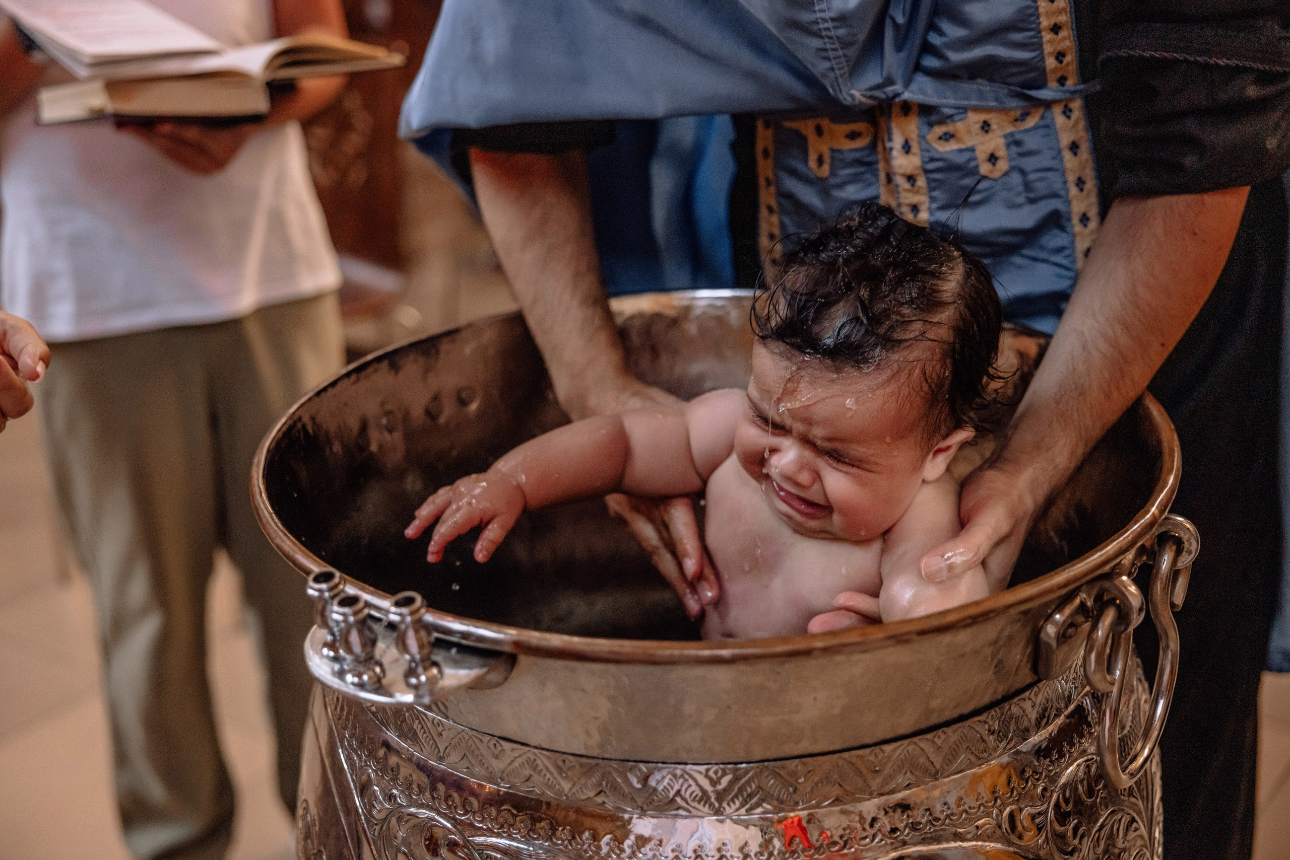 Priester taucht das Baby in Taufwasser – griechisch-orthodoxe Kirche