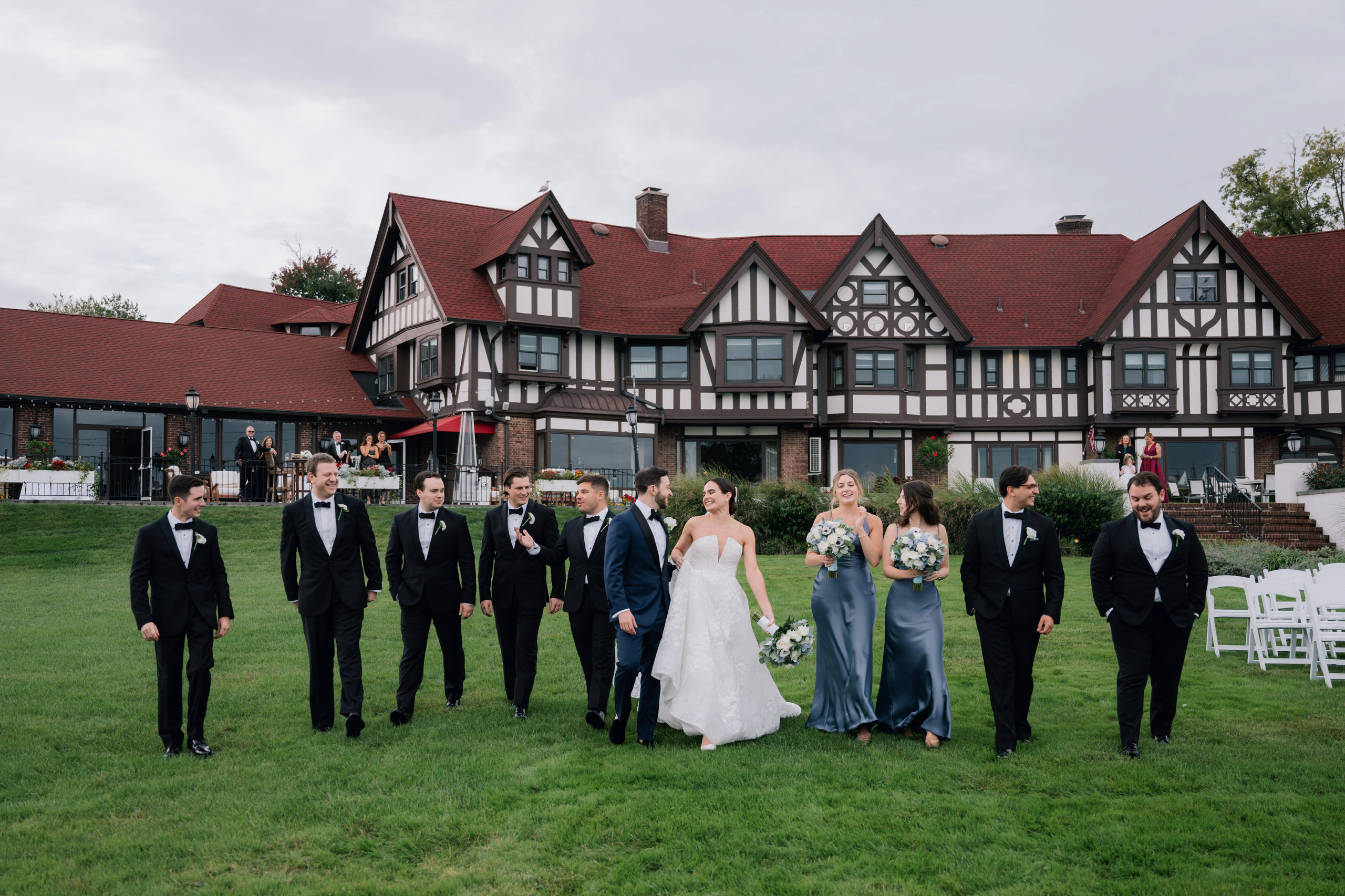 a wedding party in front of a large house