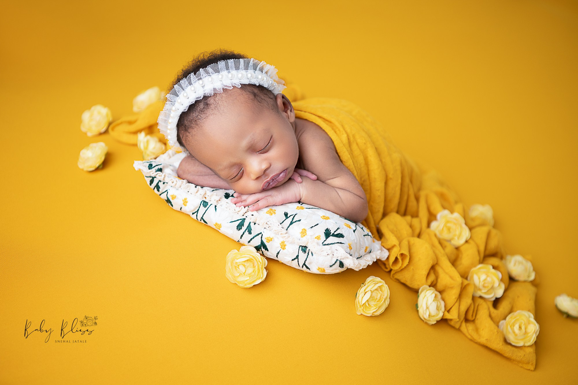 mustard yellow theme, with little tiny flowers and newborn baby is sleeping calmly.