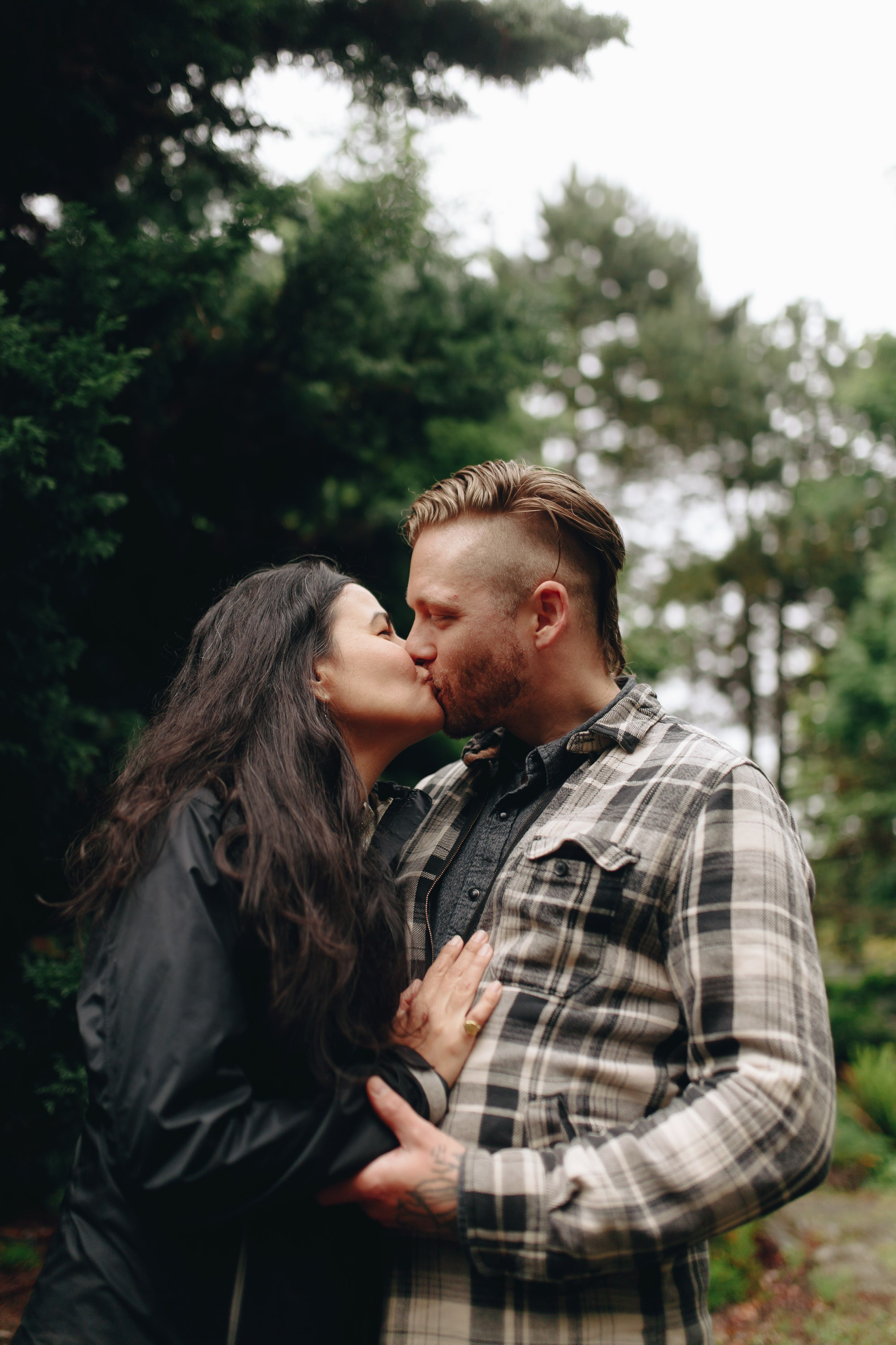 Couple hugging closely in forest