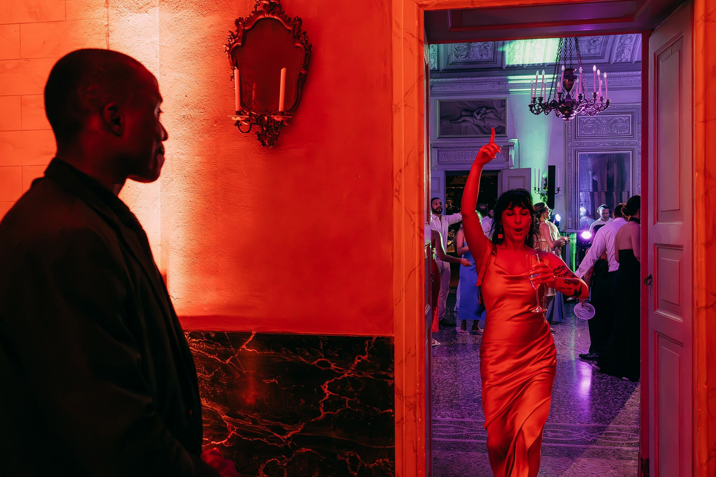 Woman joyfully entering dance floor, exuding excitement and festive spirit. The room is lighted in red.