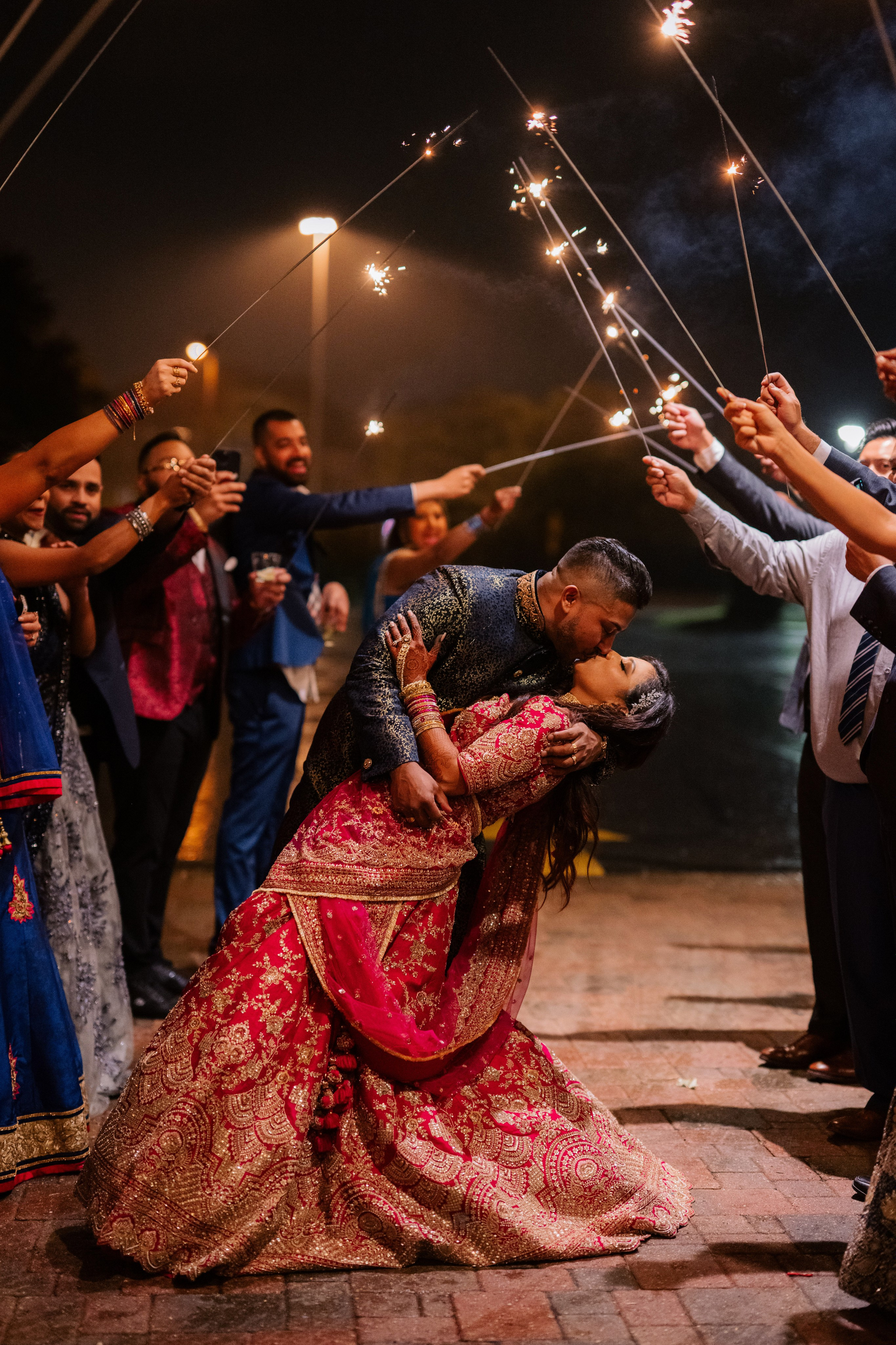 a couple is kissing while holding sparkle sticks