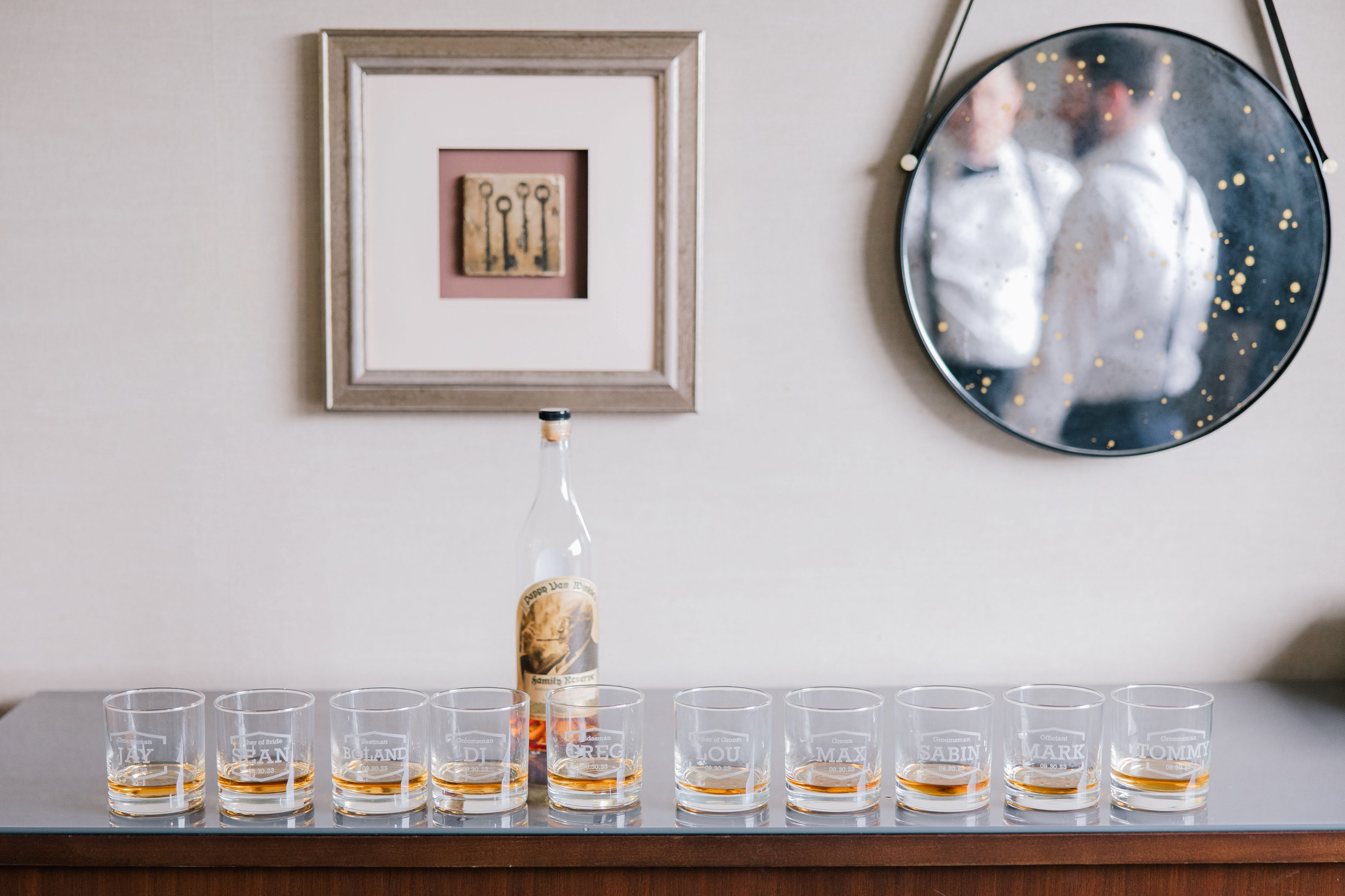 a table with glasses and a bottle of whiskey