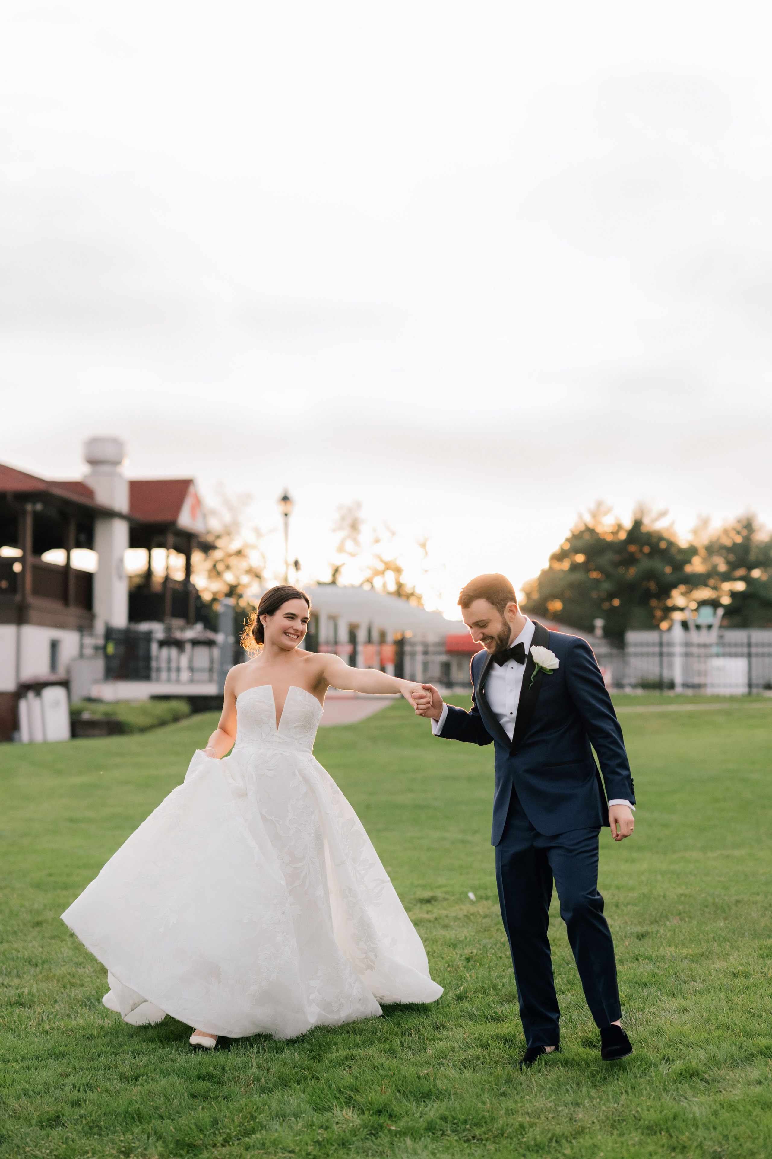 a bride and groom are playing in the grass