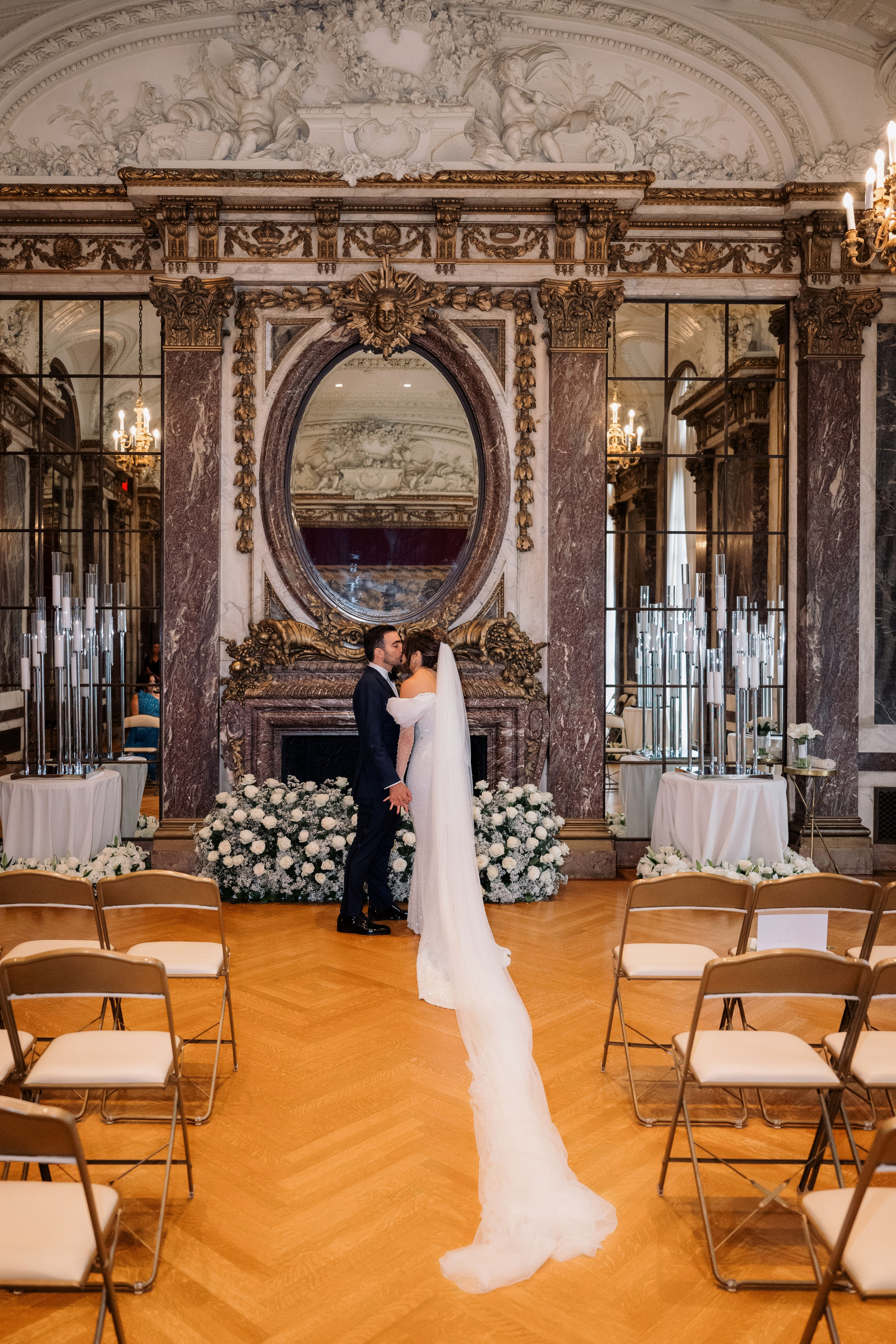 a bride and groom standing in a room with chairs