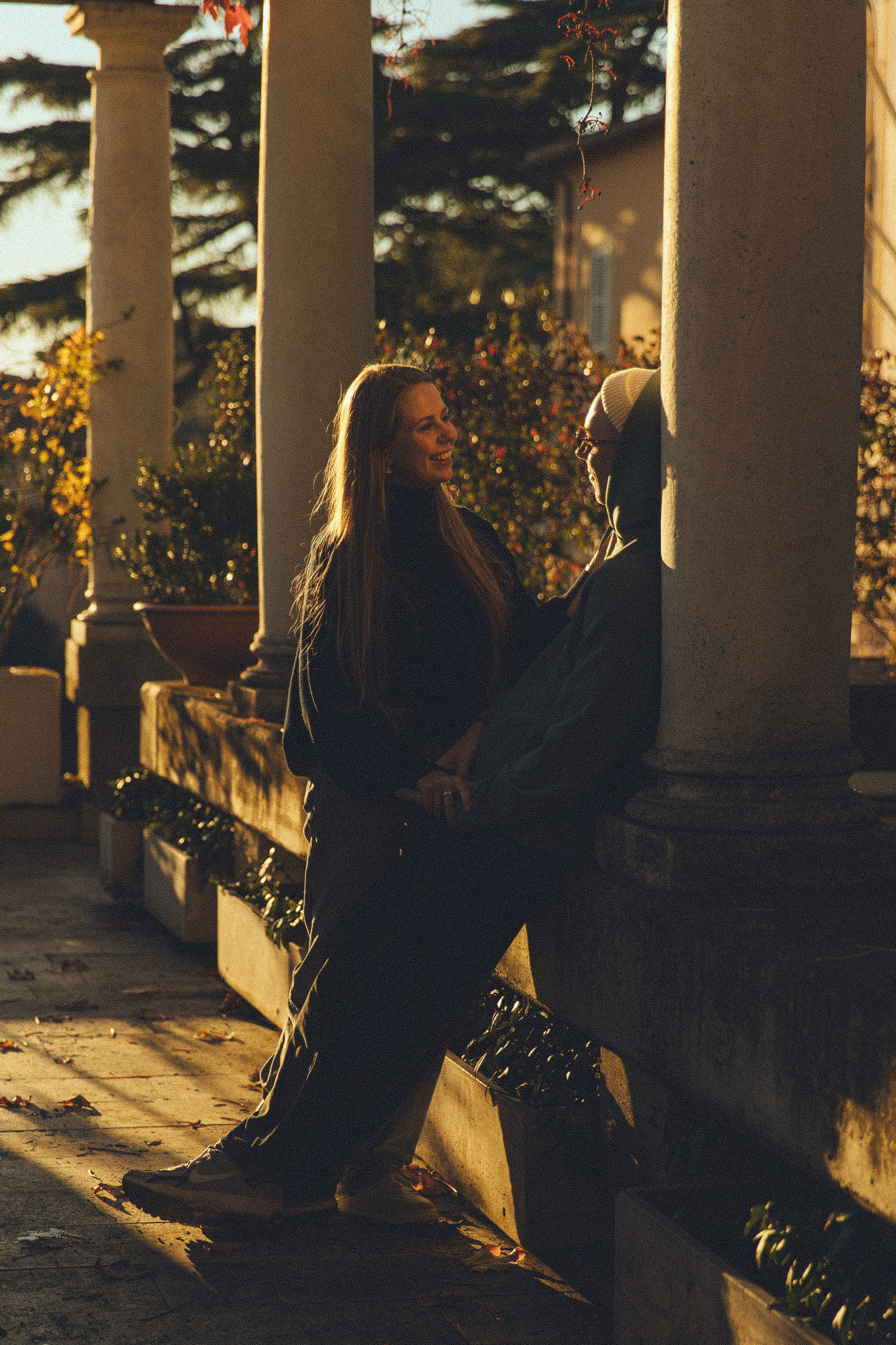 A candid photograph of a couple embracing on the sunset in Rome, their expressions full of love.