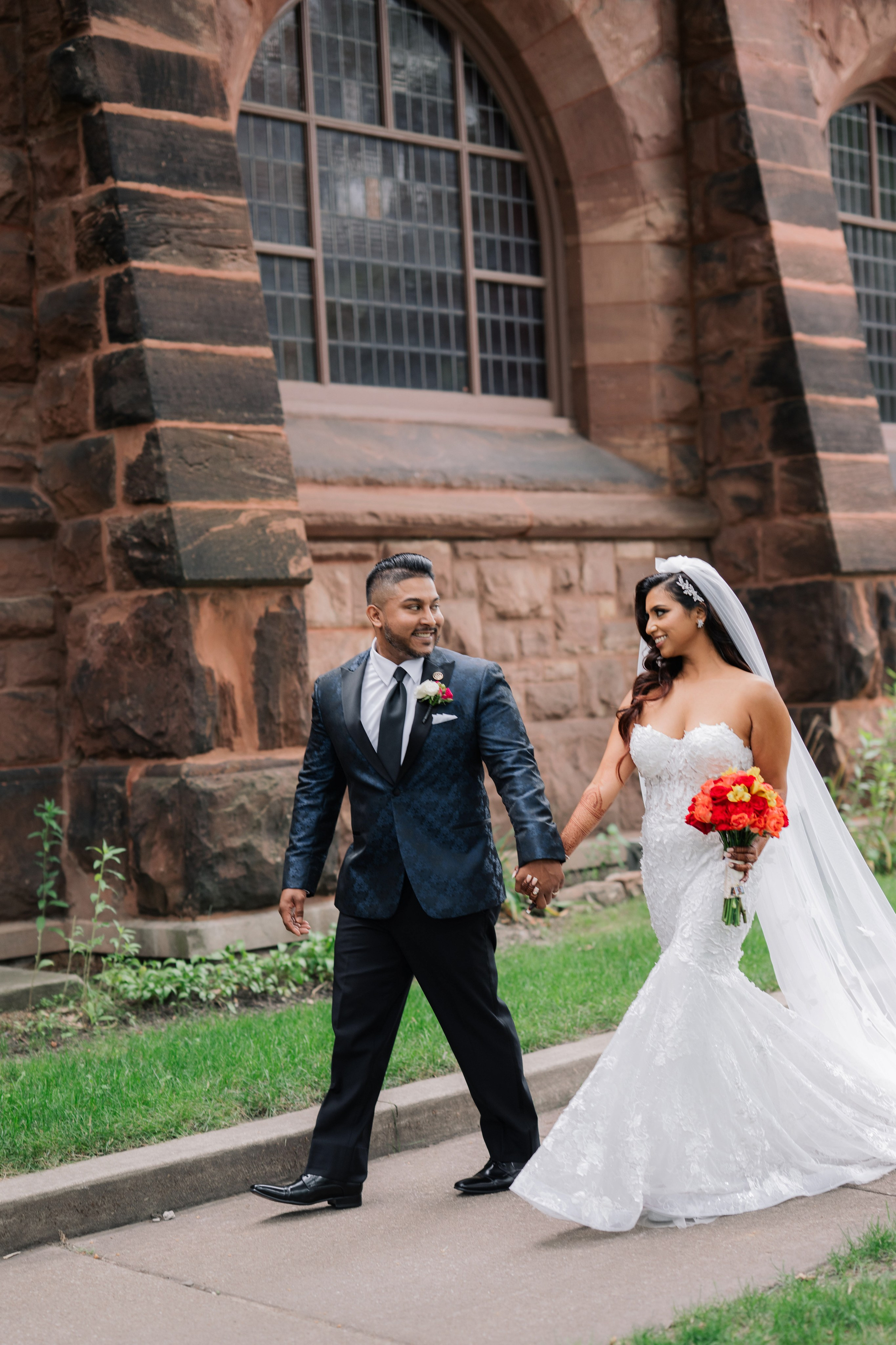 a bride and groom walking down the street