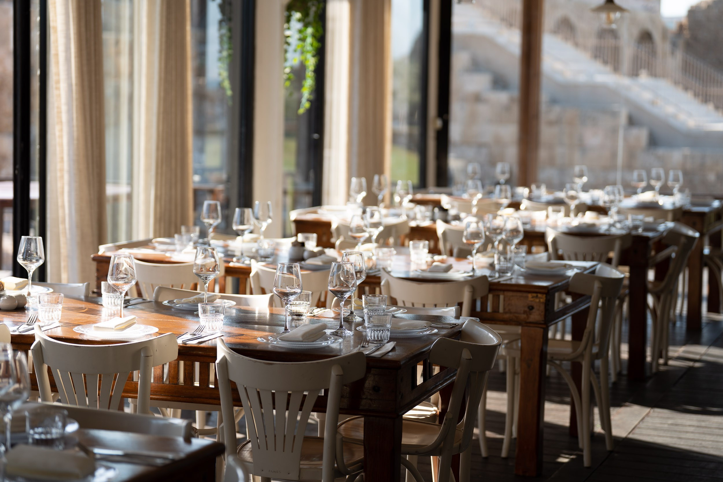 Sunlit tables prepared for the wedding reception at Aresto