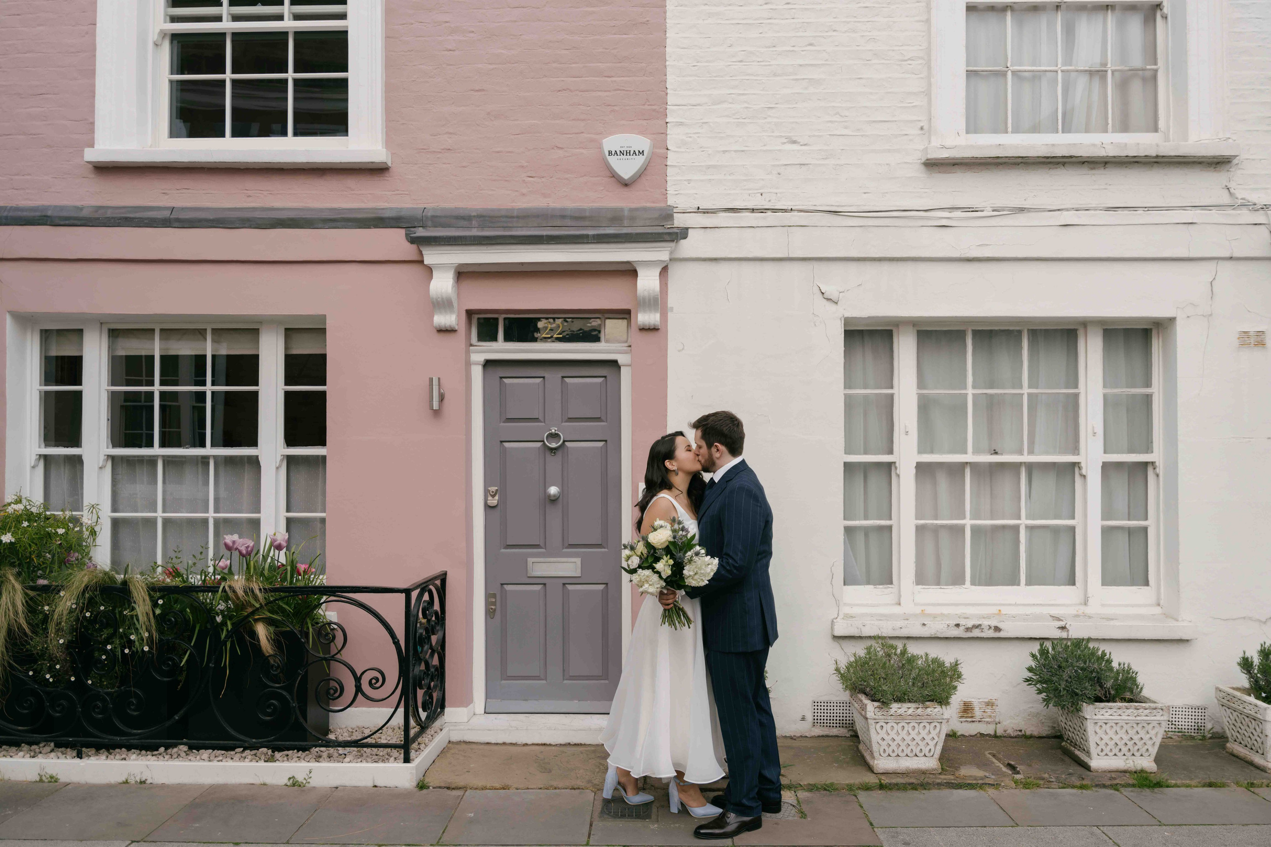 London wedding portraits in Chelsea with pastel houses and blooming trees, relaxed and cinematic style