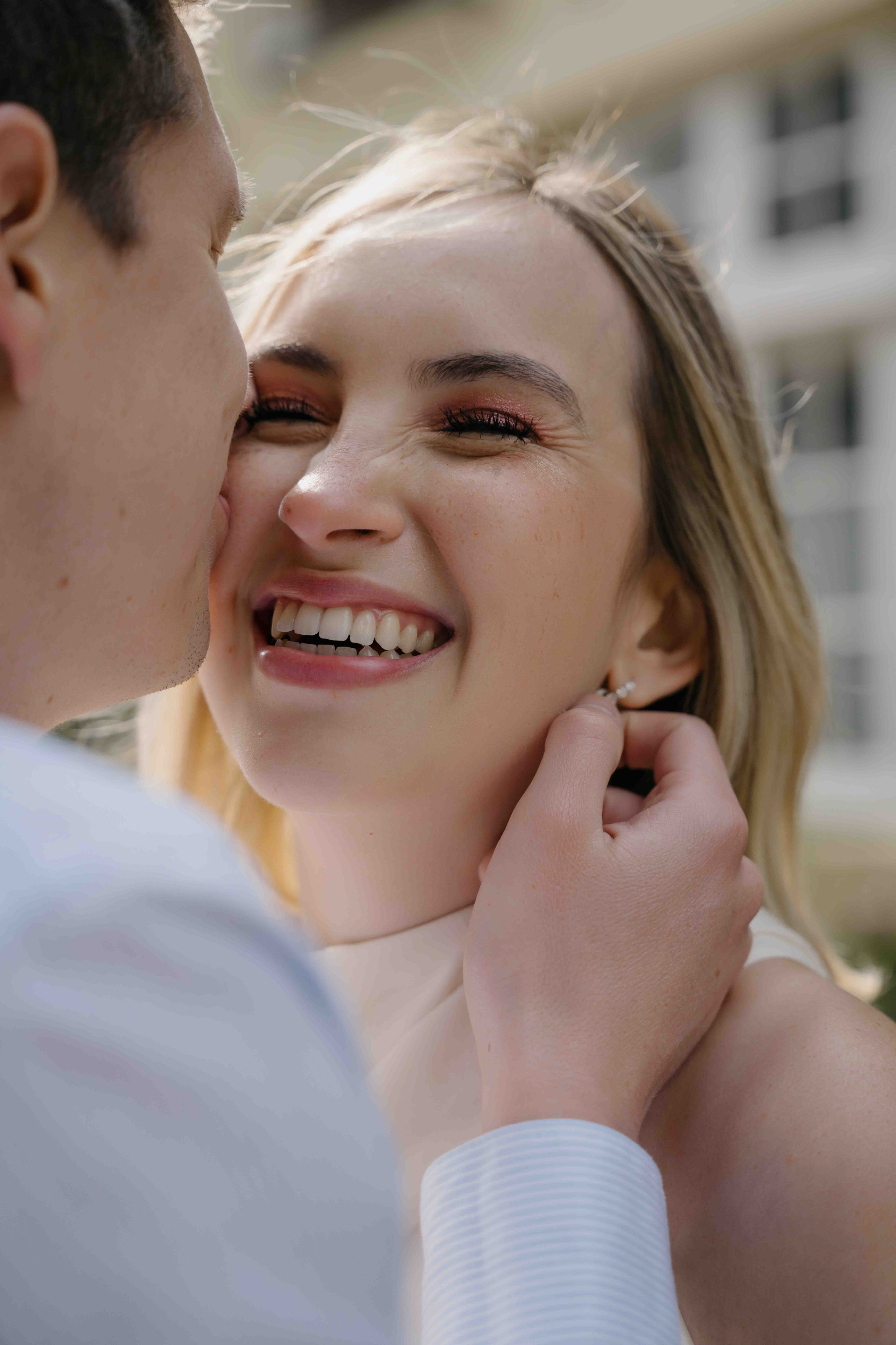 Intimate moment where a man kisses a woman on the cheek while holding her neck during a London engagement photoshoot