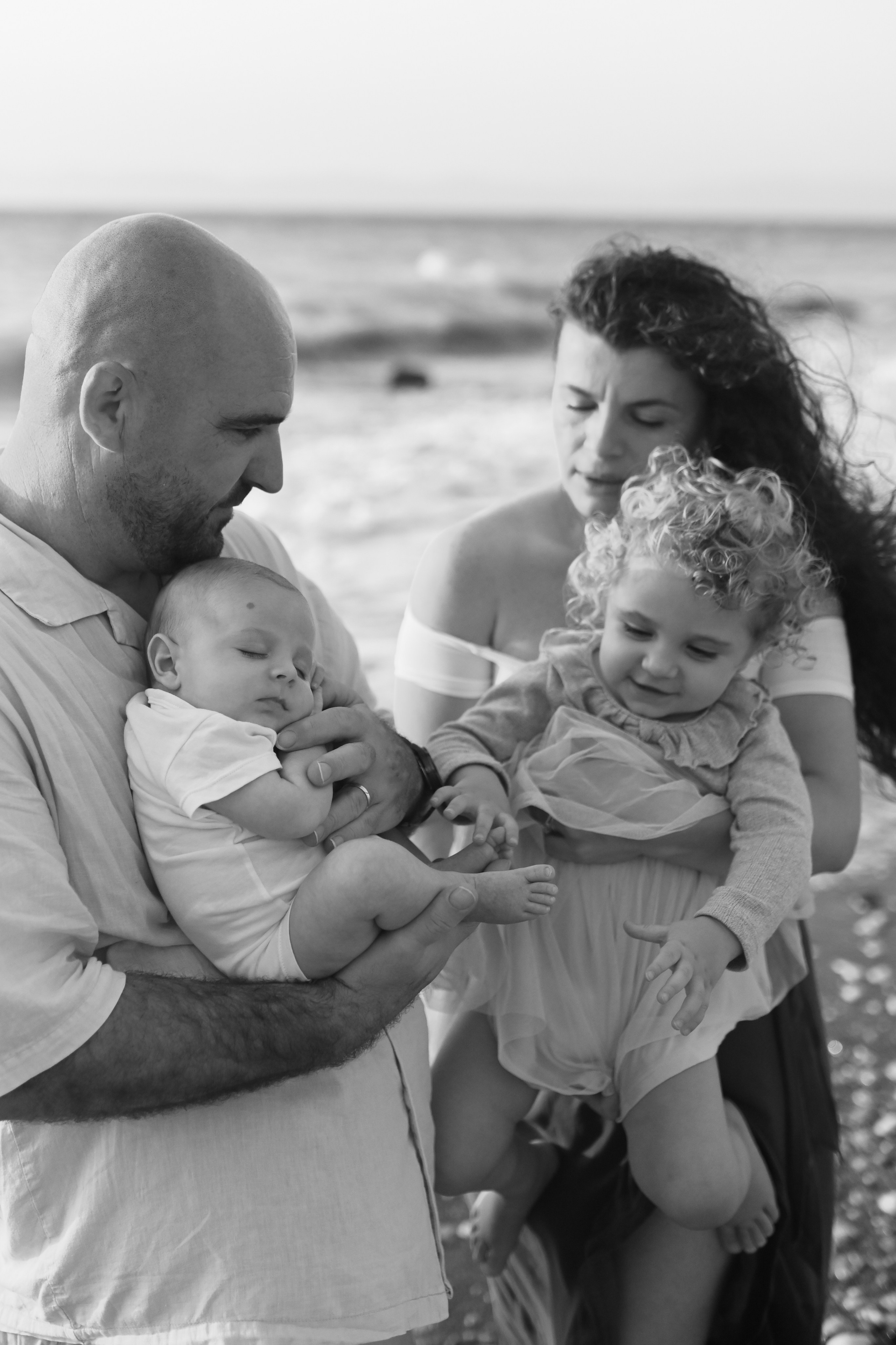 Happy family walking along a Rhodes beach at sunset. Photographer in Rhodes Island