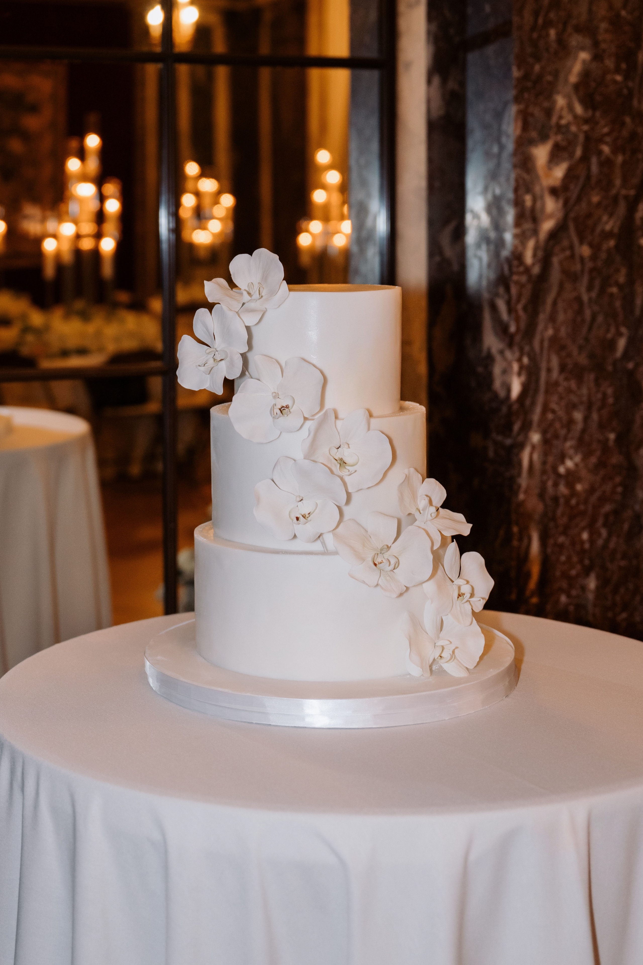a white wedding cake with white flowers on a table
