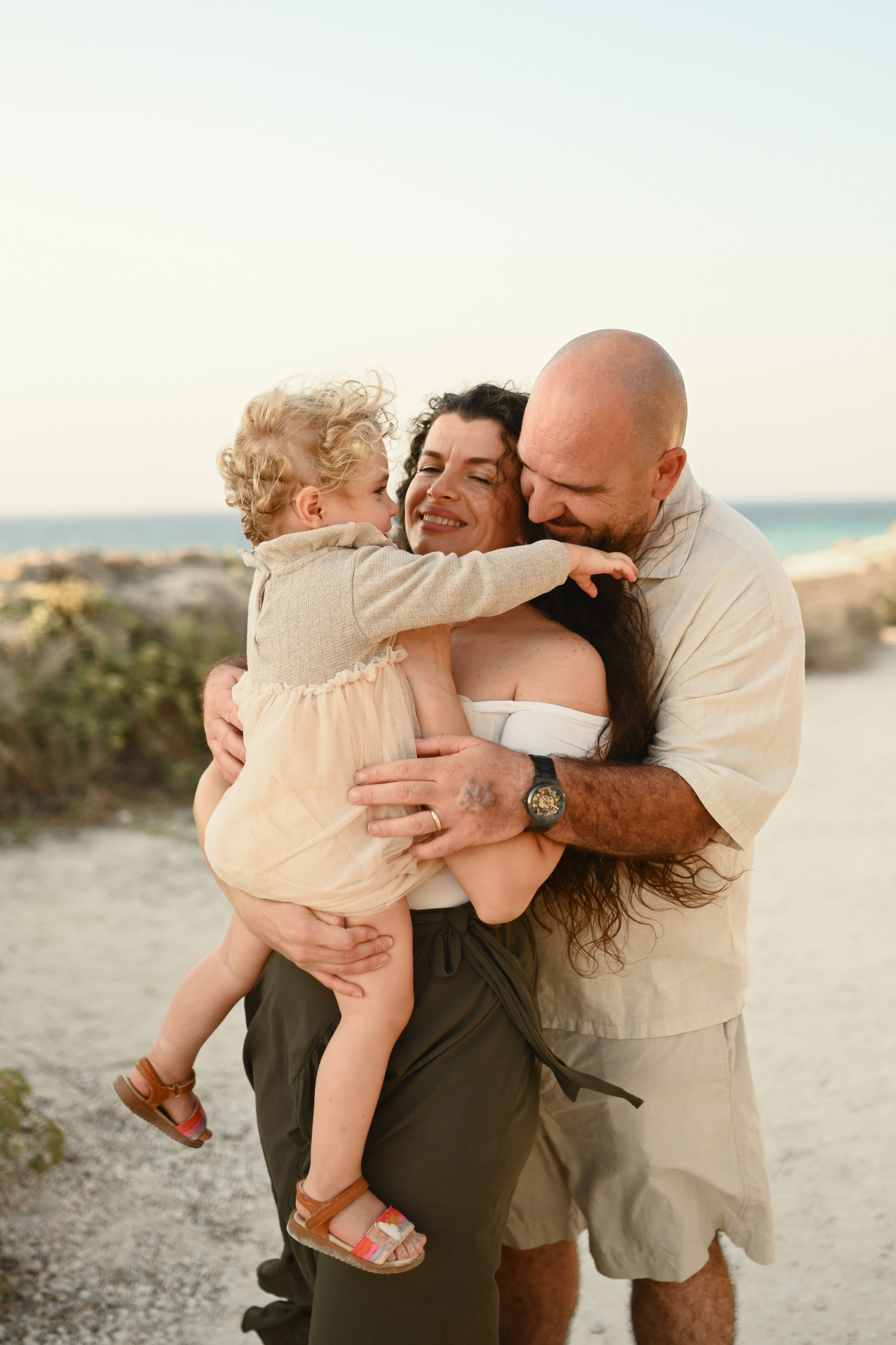 Happy family walking along a Rhodes beach at sunset. Photographer in Rhodes Island