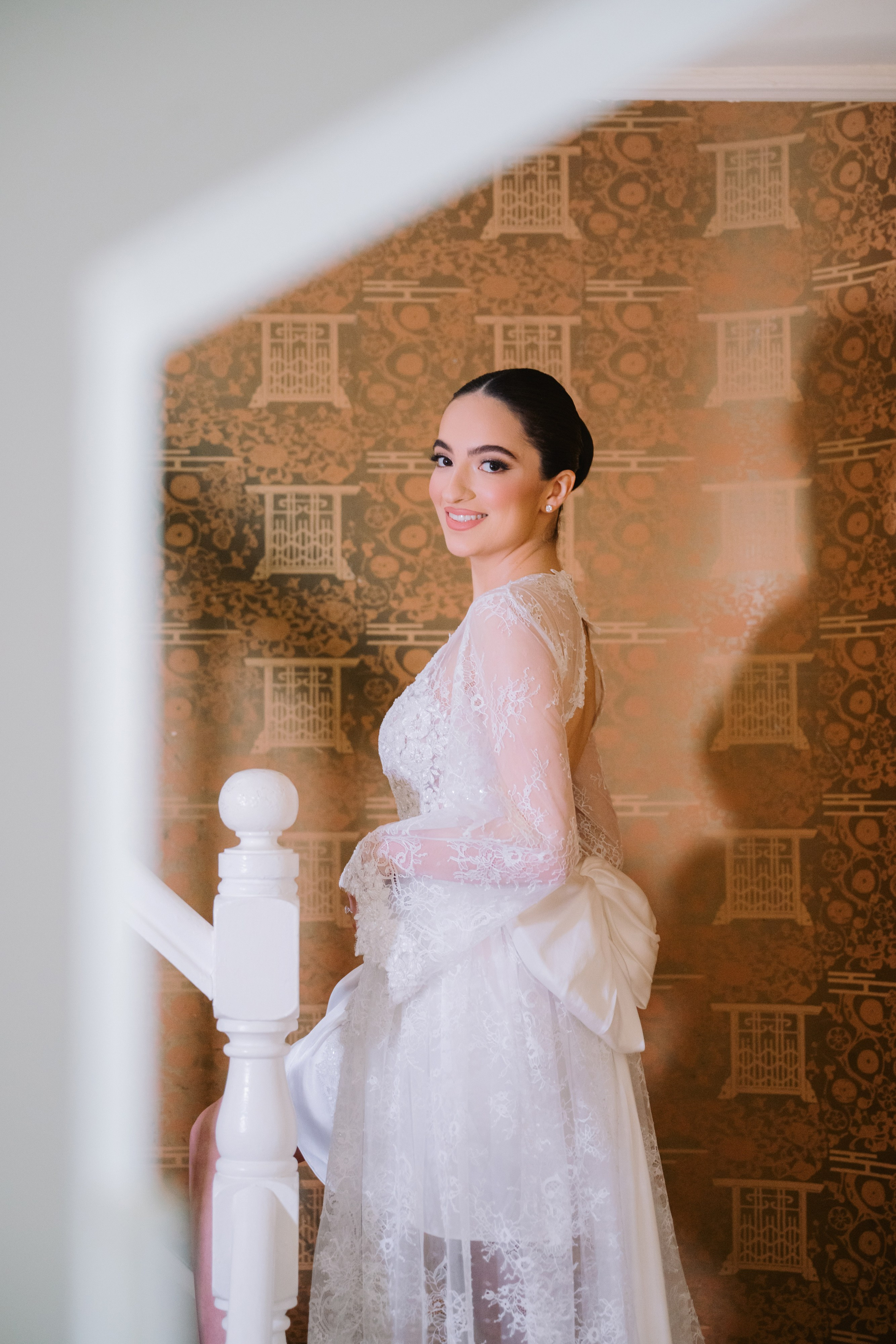 a bride in a white dress standing on a staircase