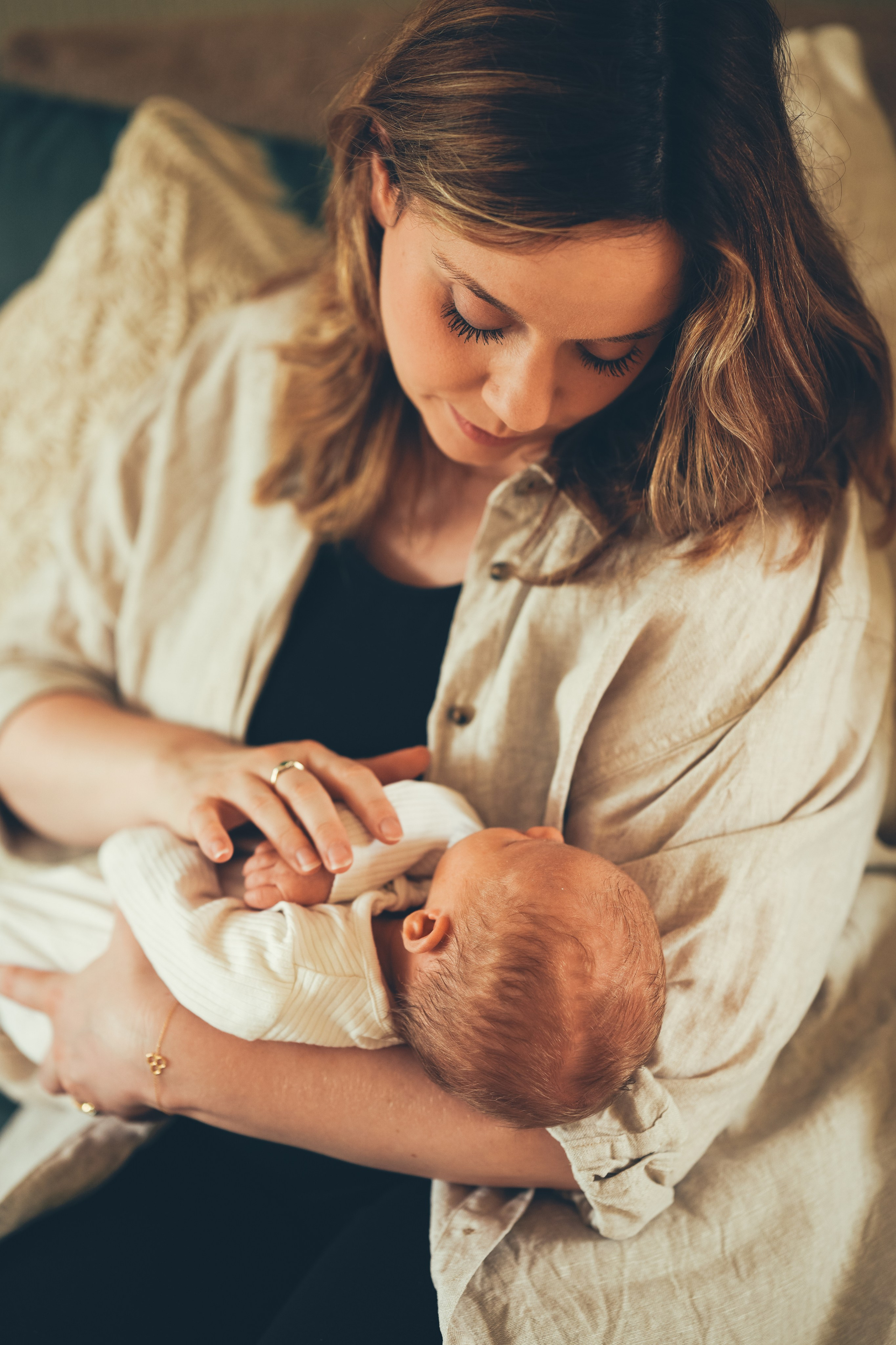Mum is holding newborn baby home photo shoot in Birmingham and Solihull
