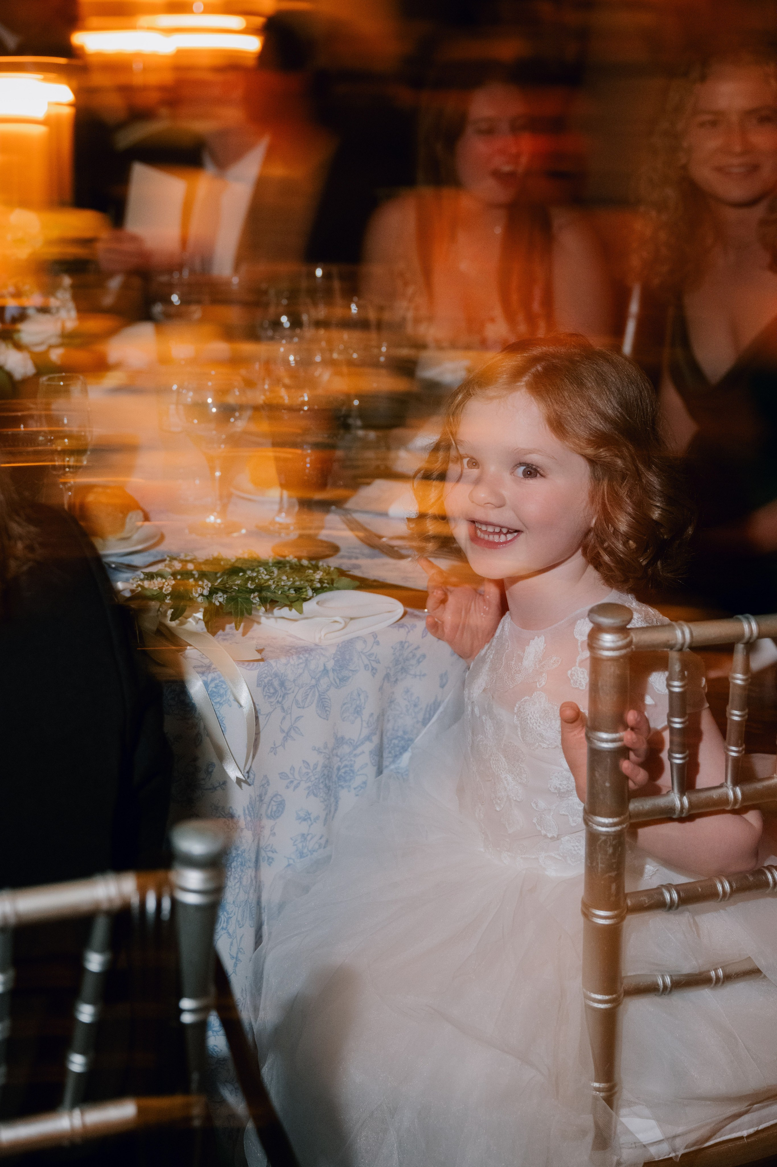 a little girl sitting in a chair at a table