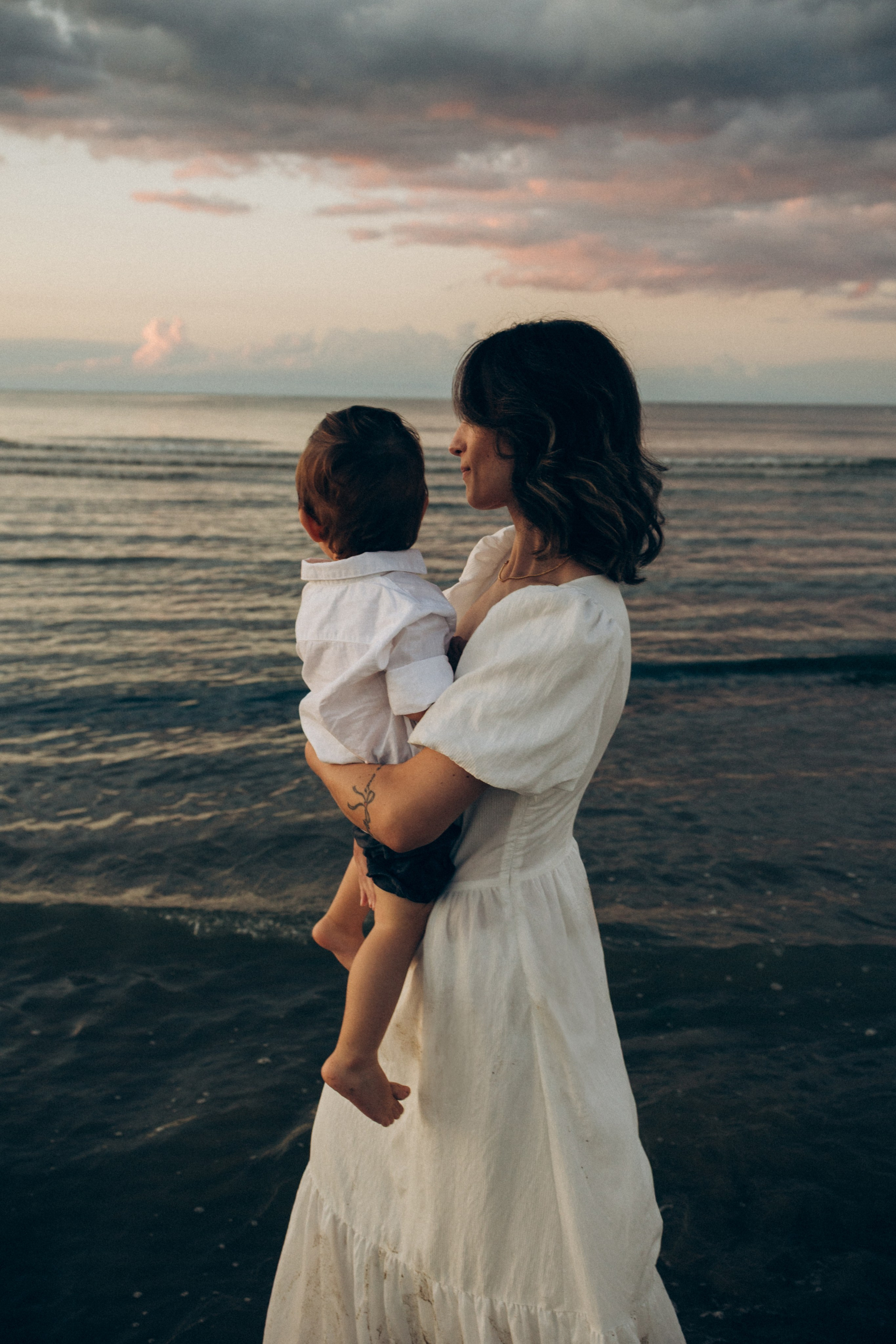 Madre con il suo bambino sulla spiaggia di Bellaria. Toni delicati, tempo rallentato e intimità autentica nella fotografia di famiglia.
