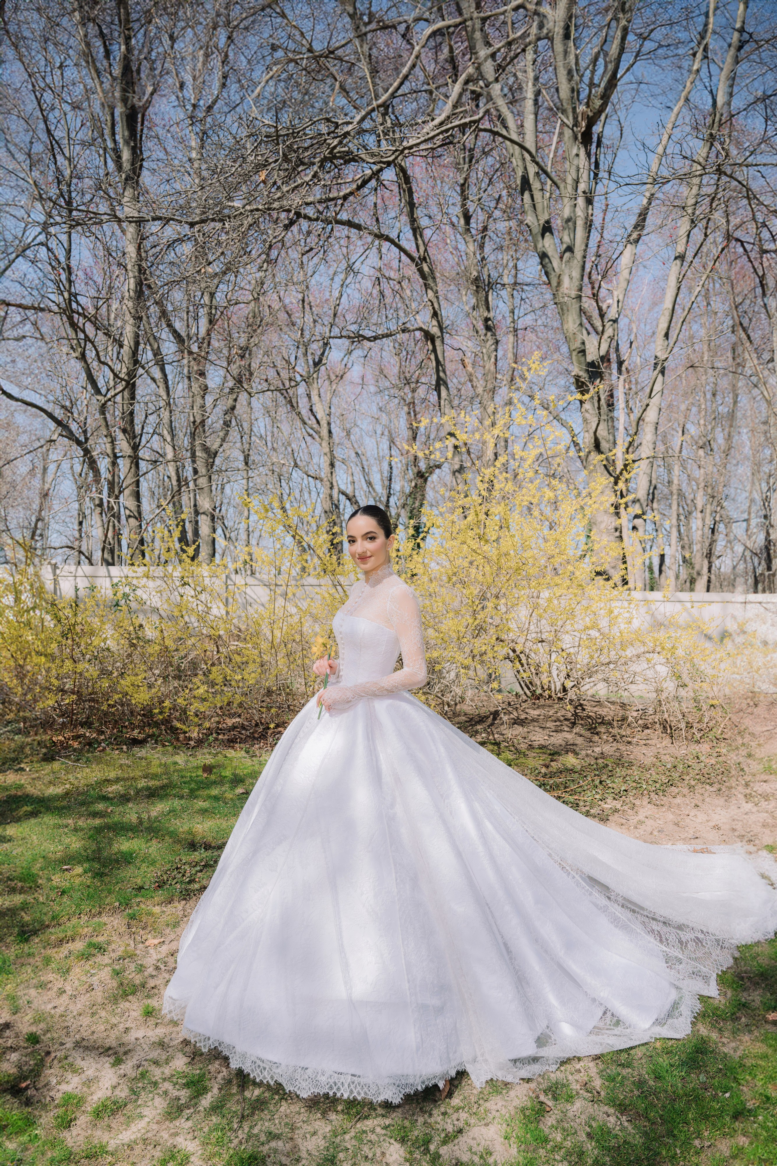 a bride in a white wedding dress standing in the grass