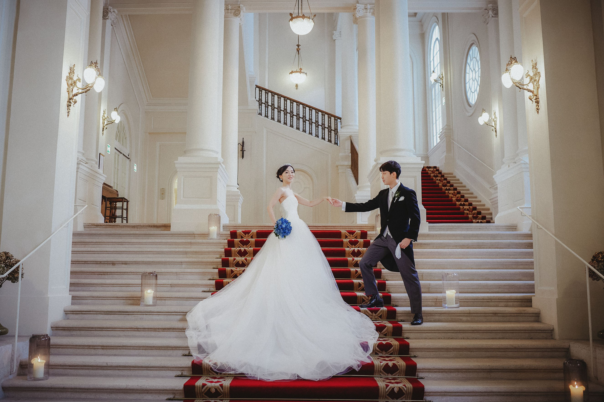 The groom takes his bride by the hand inside the Palais Coburg.