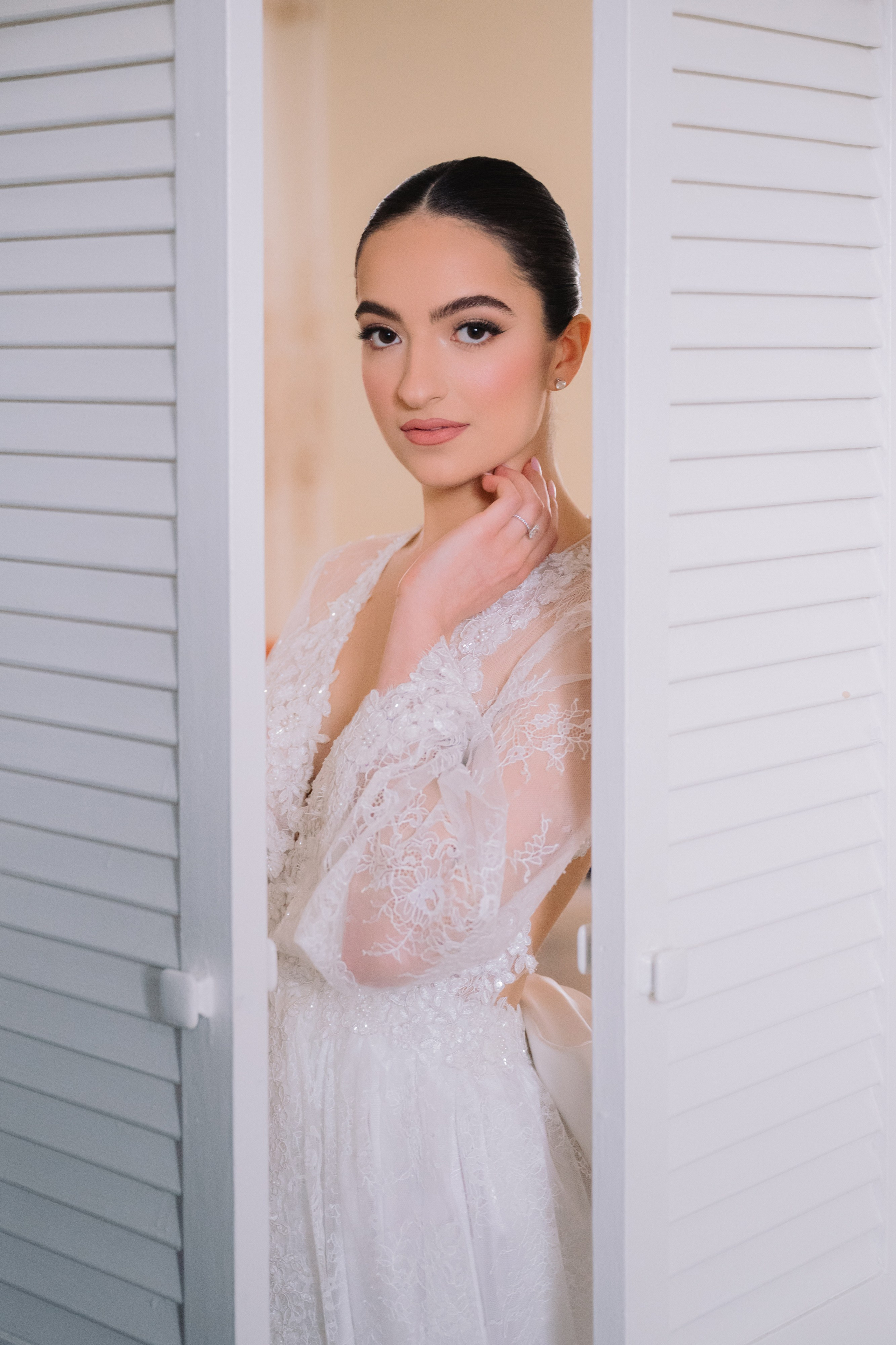 a woman in a white dress is looking out the window