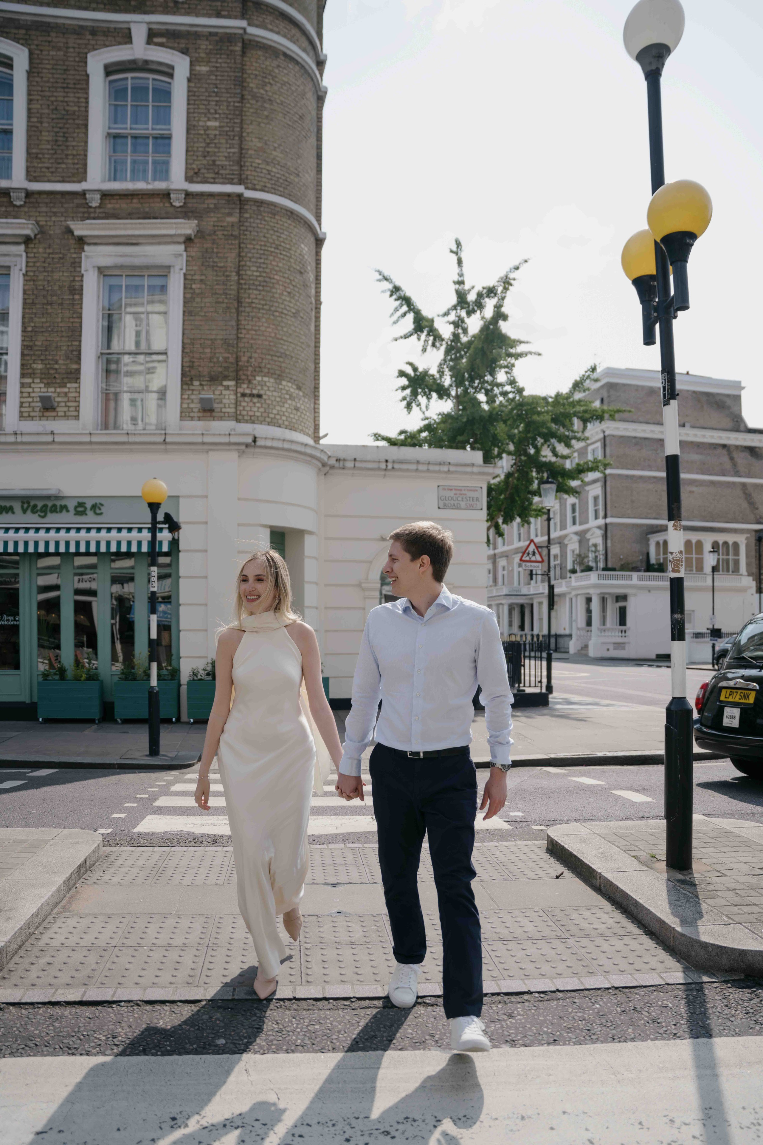 Couple crossing the street together in South Kensington London during a natural candid engagement photoshoot