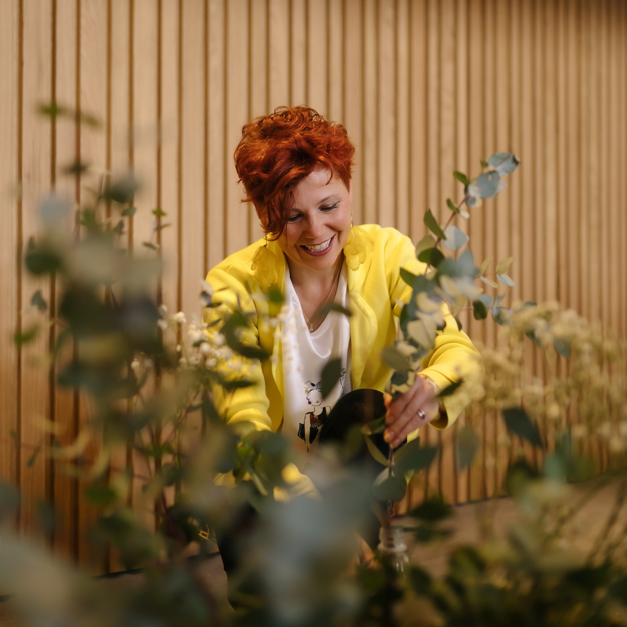 Frauenporträt einer Floristin und Einrichtungsberaterin, die kreativ mit Pflanzen und Dekor arbeitet