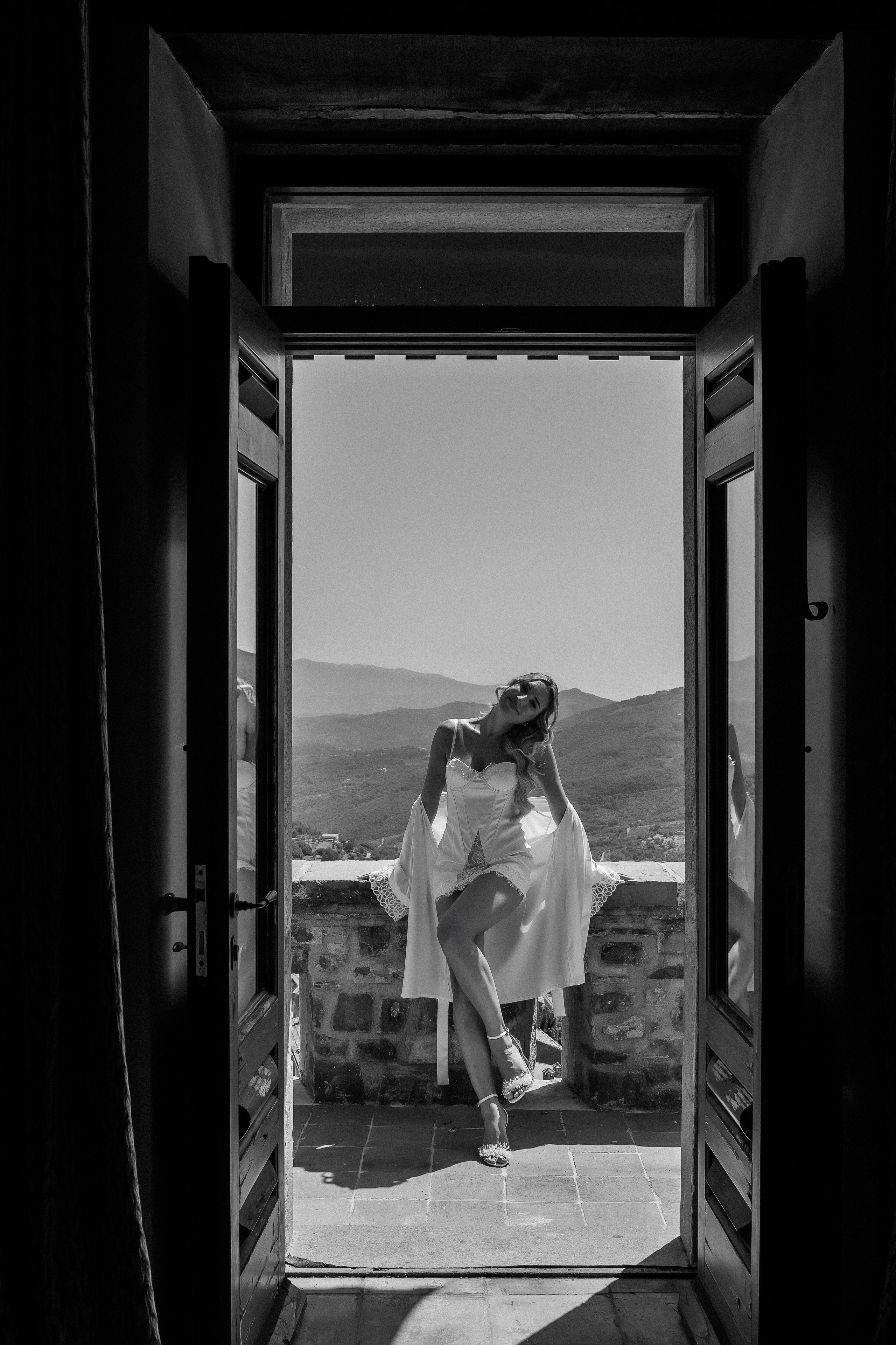 Black and white shot of the bride framed by the open castle doors