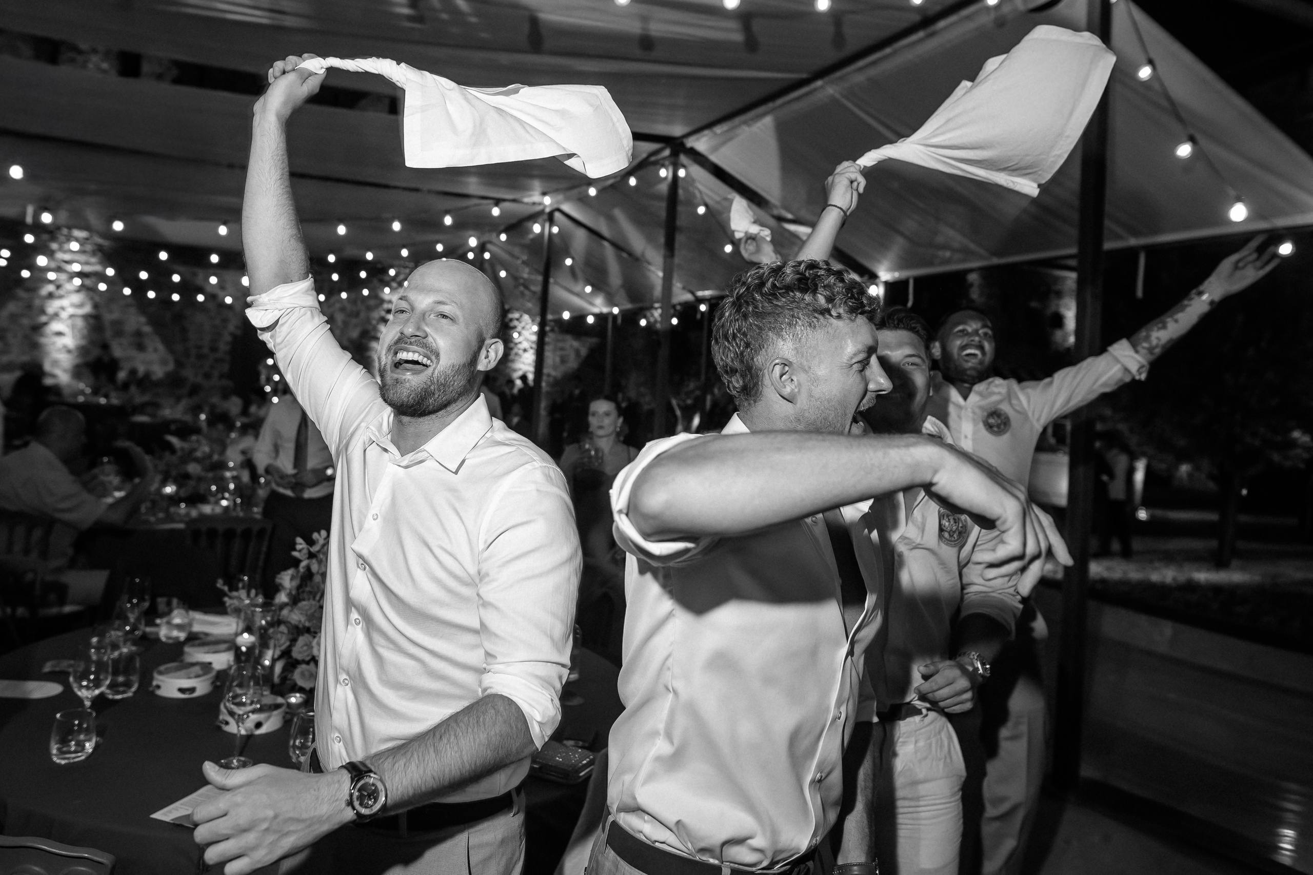 Guests celebrating on the dance floor, in black and white