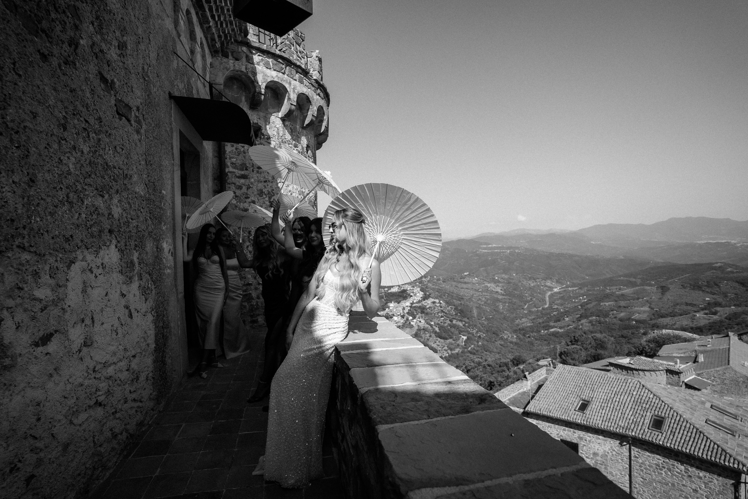 Black and white photo of guests with parasols on the castle terrace