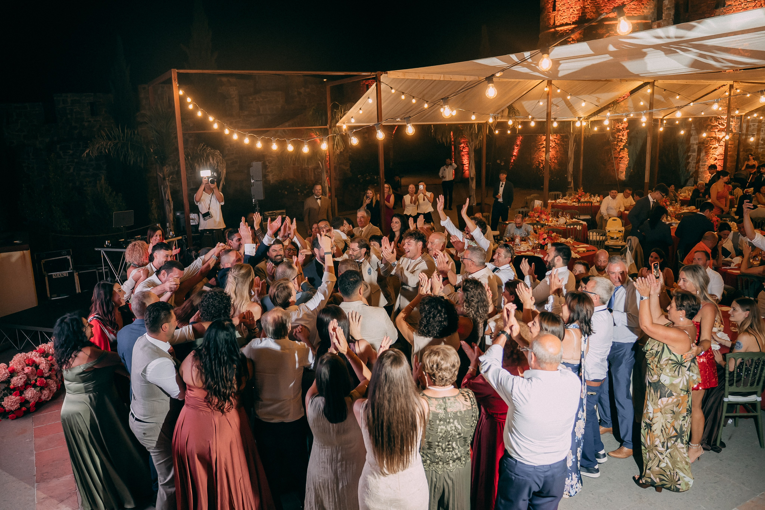 Guests dancing with their hands up under the marquee lights